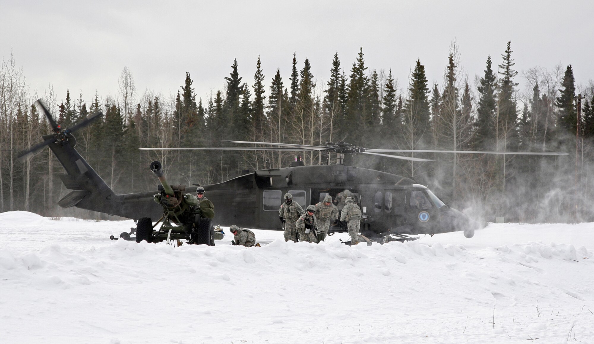 Soldiers from Alpha Battery 2d Battalion, 377th parachute Field Artillery Regiment conduct an air assault raid from an Alaska National Guard UH-60 Blackhawk at Landing Zone Ranger.