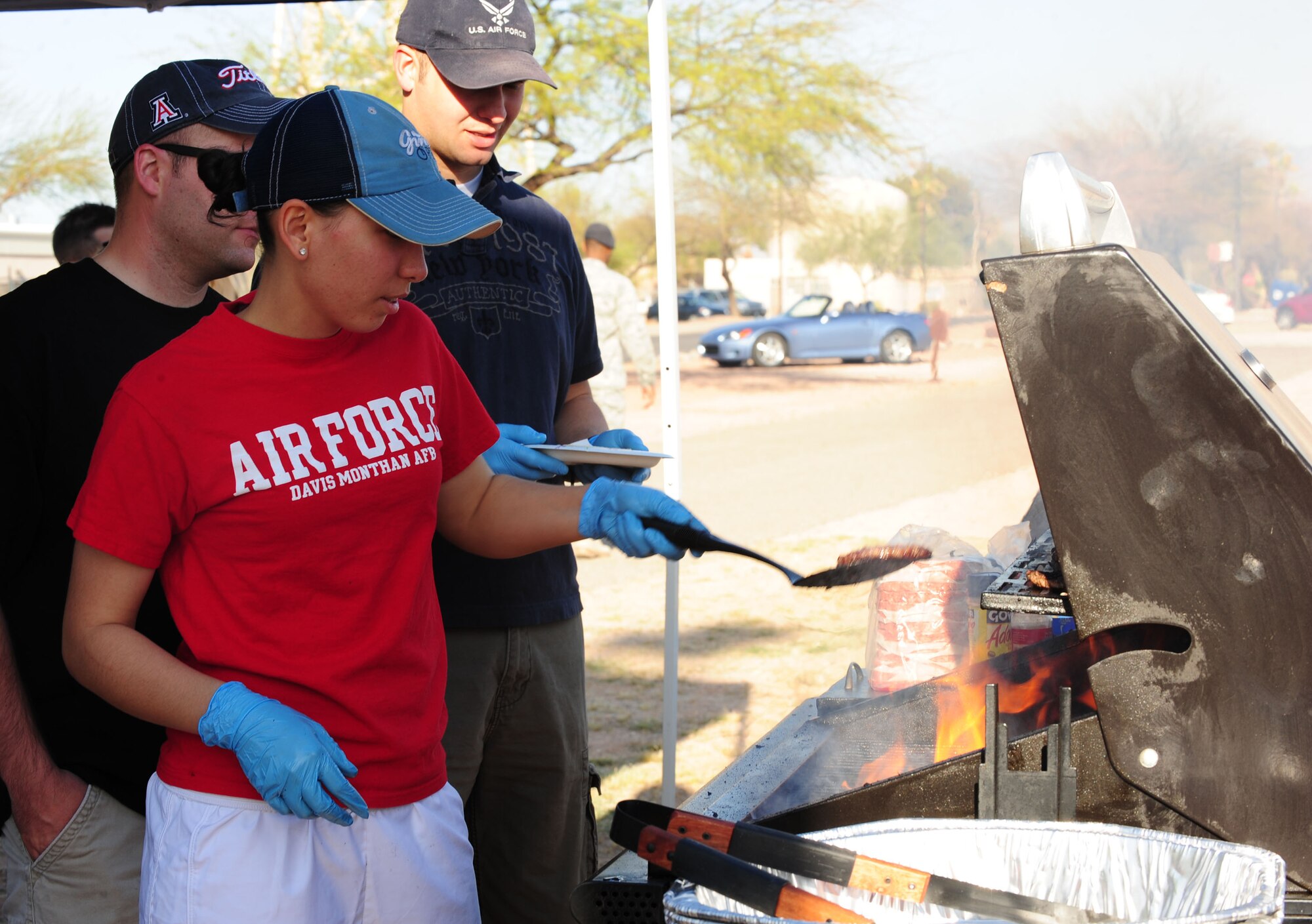 DAVIS MONTHAN AIR FORCE BASE, Ariz. - Airman 1st Class Natalia Baez-Alvarez, Desert Lightning 1st Six Council events coordinators, grills hamburgers during the charity baseball game between the Chiefs and Eagles March 25. The 1st Six sold concessions during the game with the proceeds benefitting "Ruckin' for Veterans," the 1st Six and the Japanese relief efforts. (U.S. Air Force Photo/Airman 1st Class Jerilyn Quintanilla)