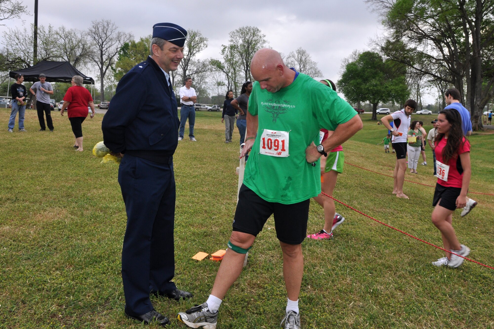 Brig. Gen. John J. Mooney III, commander, 307th Bomb Wing, Barksdale Air Force Base, La., discusses race results with Tommy Gallagher, a personal trainer from Ruston, La., after he completed the 5K portion of the Overton Brooks VA Medical Center’s 2nd Annual Warrior Run at Veterans Park in Shreveport, La., March 26, 2011. General Mooney was on hand at the annual event to start the race, but remained to congratulate participants as they crossed the finish line. The proceeds raised at the event will support OBVAMC Voluntary Service programs such as: homeless Veteran services, rehabilitation equipment, social service assistance, comfort items, transportation, holiday gifts and other volunteer funded services. (U.S. Air Force photo/Tech. Sgt. Jeff Walston)