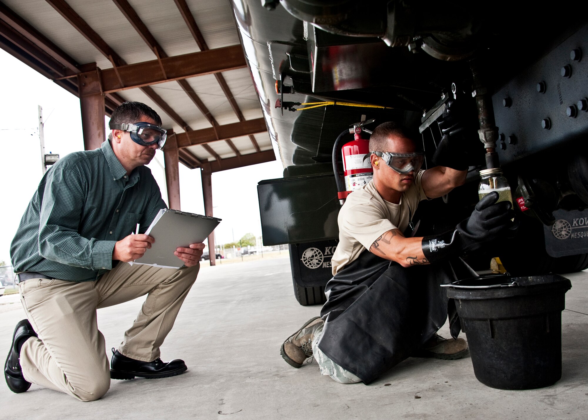 Gerald McGrael, 96th Logistics Readiness Squadron quality assurance office, monitors Senior Airman Todd Crysler, 96th LRS fuels, obtain a visual sample of JP-8 gas March 29 at Eglin Air Force Base, Fla.  The sample is taken to check for water and sediment in the fuel.  QA is responsible for evaluating the variety of different processes and standards maintained in LRS.  U.S. Air Force photo/Samuel King Jr.)