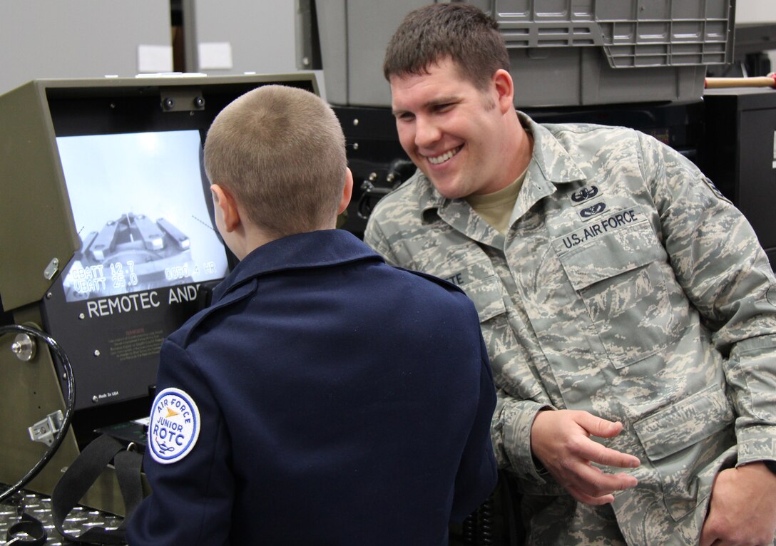 Senior Airman Blake Witte, an explosive ordnance disposal specialist, (932nd Airlift Wing) watches an Air Force JROTC cadet operate the controls of a mobile robot.   The cadets also heard briefings from medical and aircraft maintenance personnel and toured the C-40 and C9-C aircraft.  The cadets were visiting Scott Air Force Base, Il from St. Clair, Mo. (U.S. Air Force photo/Tech. Sgt. Dan Oliver)   