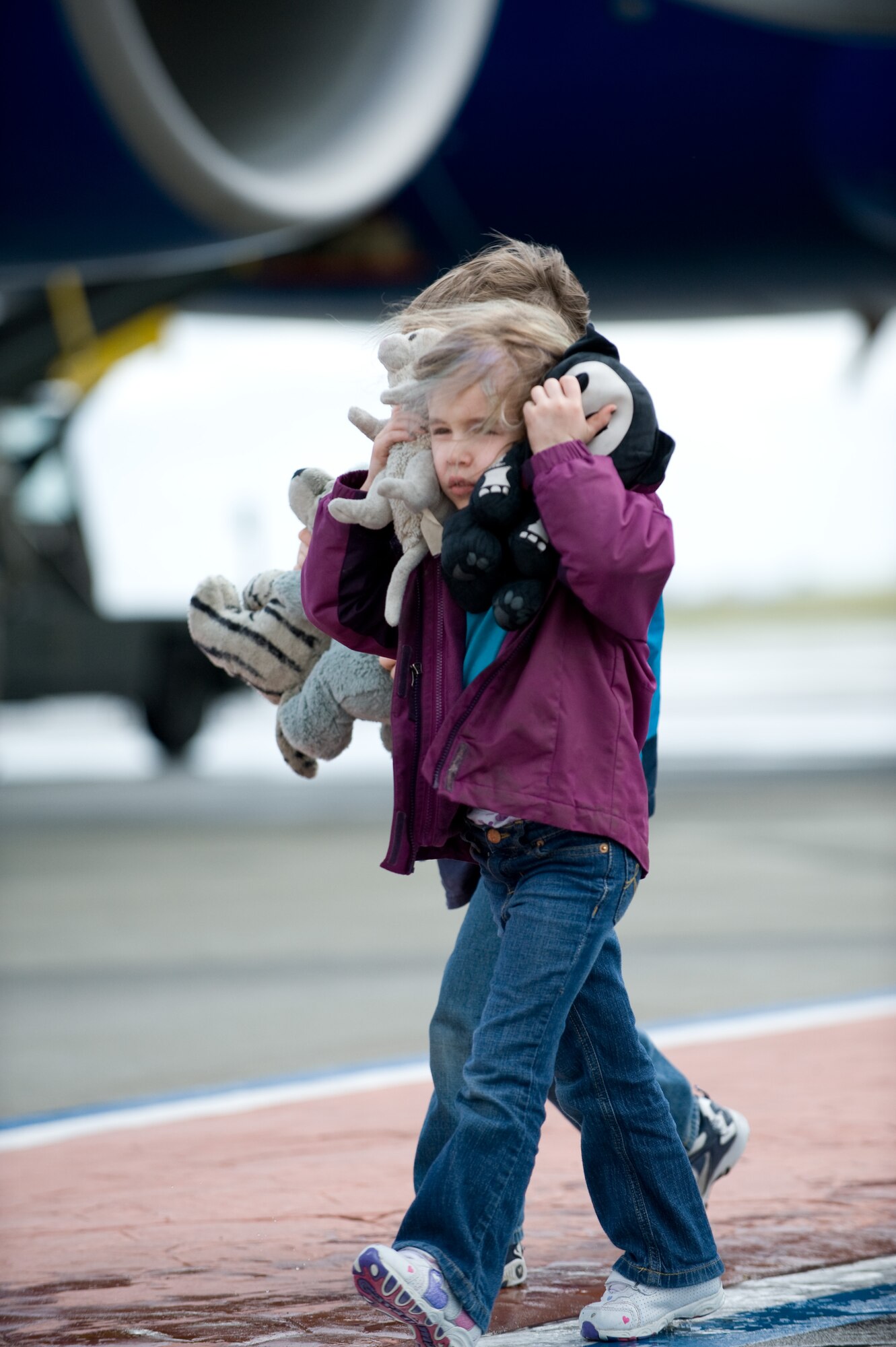 A little girl protects her ears from aircraft engine noise as she and her family arrive at Travis Air Force Base, Calif., on March 25 from Japan. Following the earthquake and tsunami that hit Japan on March 11, hundreds of family members from military bases in Japan voluntarily relocated to the United States after radiation from crippled Japanese nuclear energy plants was detected in some areas.(U.S. Air Force photo/Ken Wright)