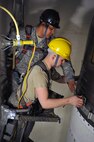 MINOT AIR FORCE BASE, N.D. -- Staff Sgt. Keith McClain (black hard hat), 91st Missile Maintenance Squadron cage man instructor, works with Airman 1st Class Douglas Schimmeck, 91st Missile Maintenance Squadron cage man technician, on job proficiency training here March 28. Airman Schimmeck is required to undergo work evaluations in order to be qualified to conduct real world tasks in the field. (U.S. Air Force photo/Staff Sgt. Keith Ballard)