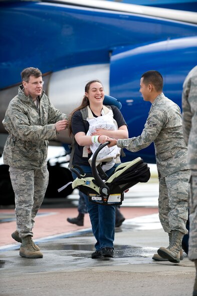 A mother and child are helped by Air Force members at Travis Air Force Base, Calif., on March 25, 2011, after arriving from Japan. Following the earthquake and tsunami that hit Japan on March 11, 2011, hundreds of family members from military bases in Japan voluntarily relocated to the United States after radiation from crippled Japanese nuclear energy plants was detected in some areas. (U.S. Air Force Photo/Ken Wright)