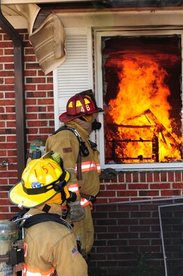 SEYMOUR JOHNSON AIR FORCE BASE, N.C. ? Vaden Lee (standing) and Brad Peele watch as members of the Goldsboro and the base fire departments work to contain a controlled burn here March 25, 2011. Lee and Peele are members of the Goldsboro Fire Department and, along with the rest of their department, participated in the live burns. Both hail from Goldsboro. (U.S. Air Force photo/Senior Airman Rae Perry) (RELEASED)