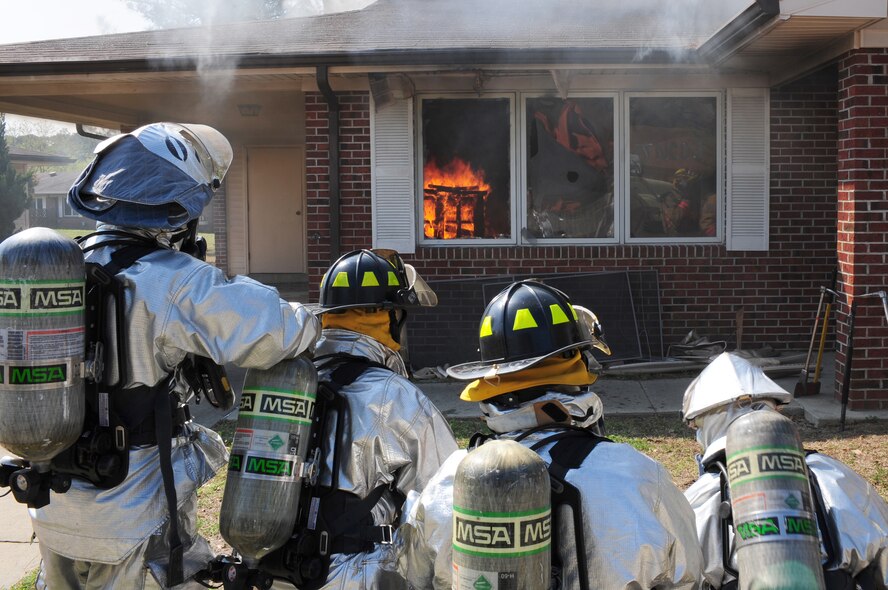 SEYMOUR JOHNSON AIR FORCE BASE, N.C. -- Four Airmen await their turn to put out a controlled fire here March 25, 2011. When fighting an uncontrolled fire, firefighters have two back up crews waiting outside the building for support. The Airmen are members of the 4th Civil Engineer Squadron's fire department. (U.S. Air Force photo/Senior Airman Rae Perry) (RELEASED)
