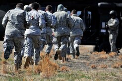 Airmen run toward a UH-60 Black Hawk helicopter during helicopter deployment readiness training March 25, 2011, at Davison Army Airfield, Va. The training will better familiarize deploying Airmen to tactical joint air operations. (U.S. Air Force Photo by Senior Airman Perry Aston) (Released)