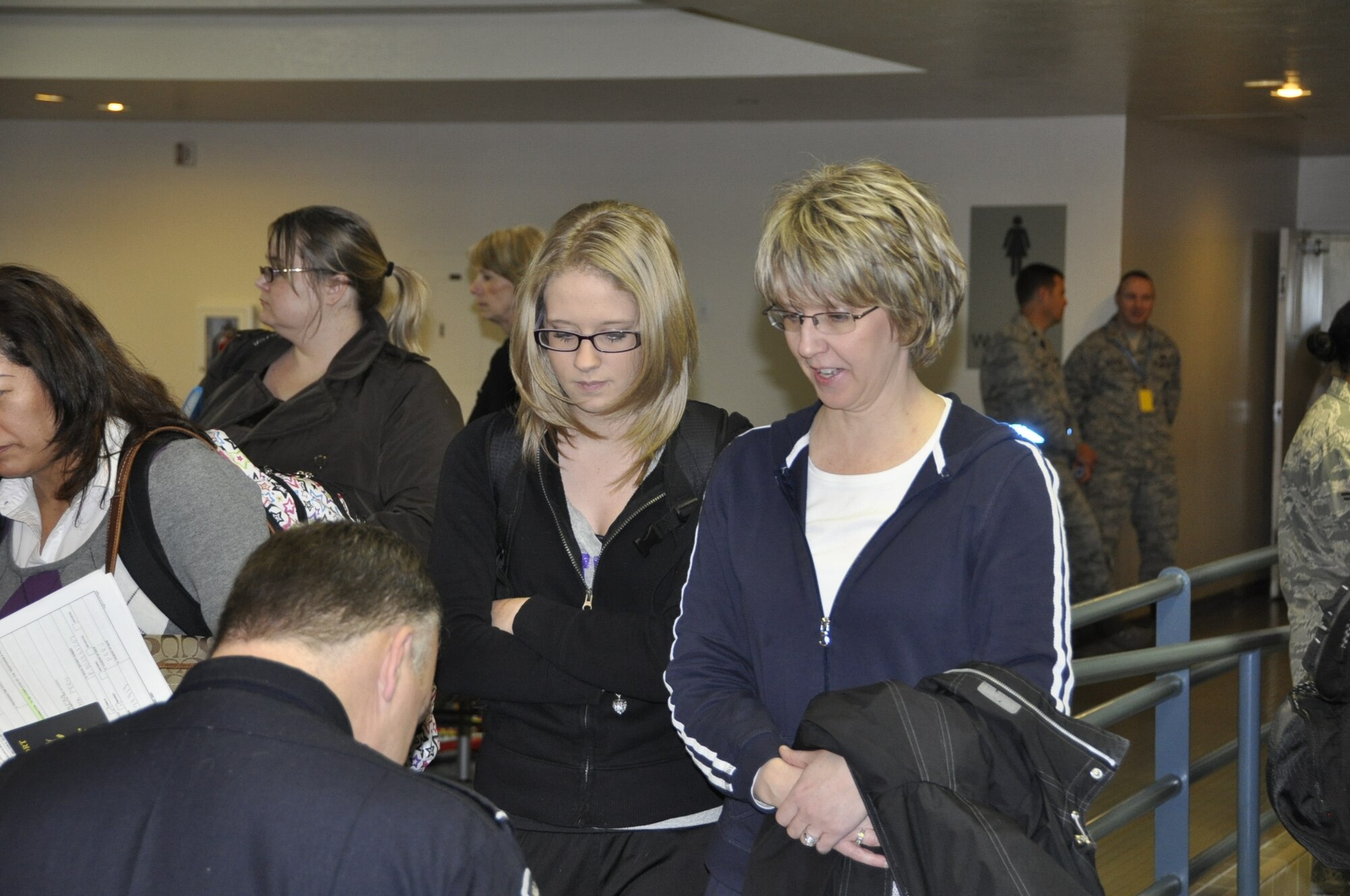 Bethany and Becky Metzger (wait to) have their passports checked after arriving March 28 at Travis Air Force Base. The pair was returning to the United States from United States Fleet Activities Yokosuka, Japan, after the 9.0 Tohoku earthquake and tsunami earlier this month. (U.S. Air Force photo/Nick DeCicco)
