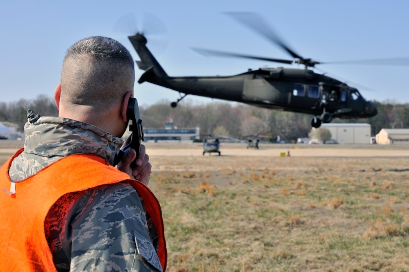 Lt. Col. Kjall Gopaul, Joint and Air Staff acting director, and helicopter deployment readiness training instructor, speaks to the pilots of a UH-60 Black Hawk helicopter, as it takes off during a training exercise March 25, 2011, at Davison Army Airfield, Va. The training is performed once a month and more than 2,000 Airman have completed the training since it began in 2003. (U.S. Air Force Photo by Senior Airman Perry Aston) (Released)