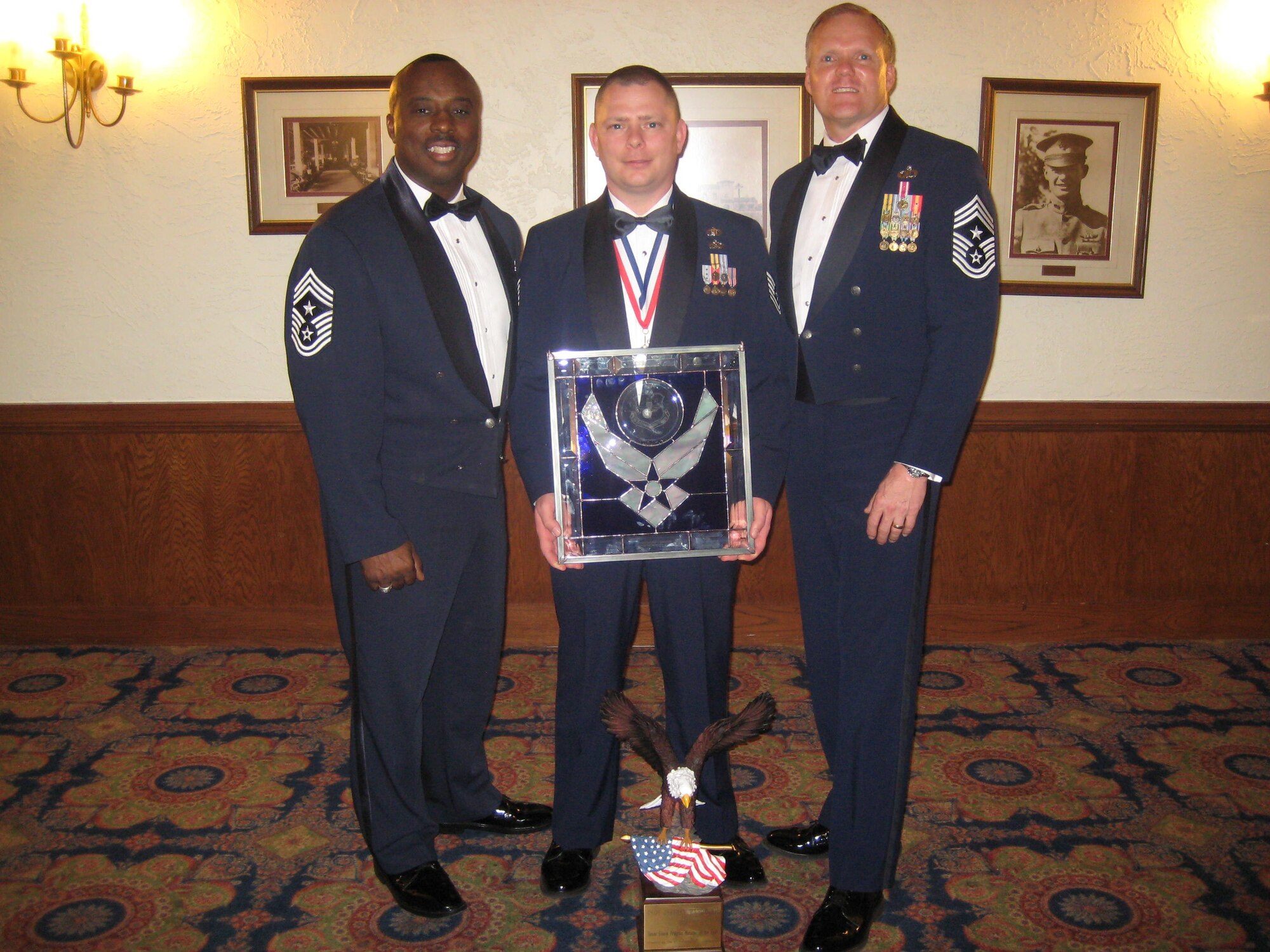 The Air Education and Training Command Honor Guard Manager of the Year, Tech Sgt. Jeffery Randolph, 14th Operations Support Squadron NCOIC, stands between 14th Flying Training Wing Command Chief Master Sgt. Zefrem Smith and AETC Command Chief Master Sgt. James Cody March 18 after a ceremony held at the Parr Officer Club at Randolph Air Force Base, Texas. (U.S. Air Force photo).