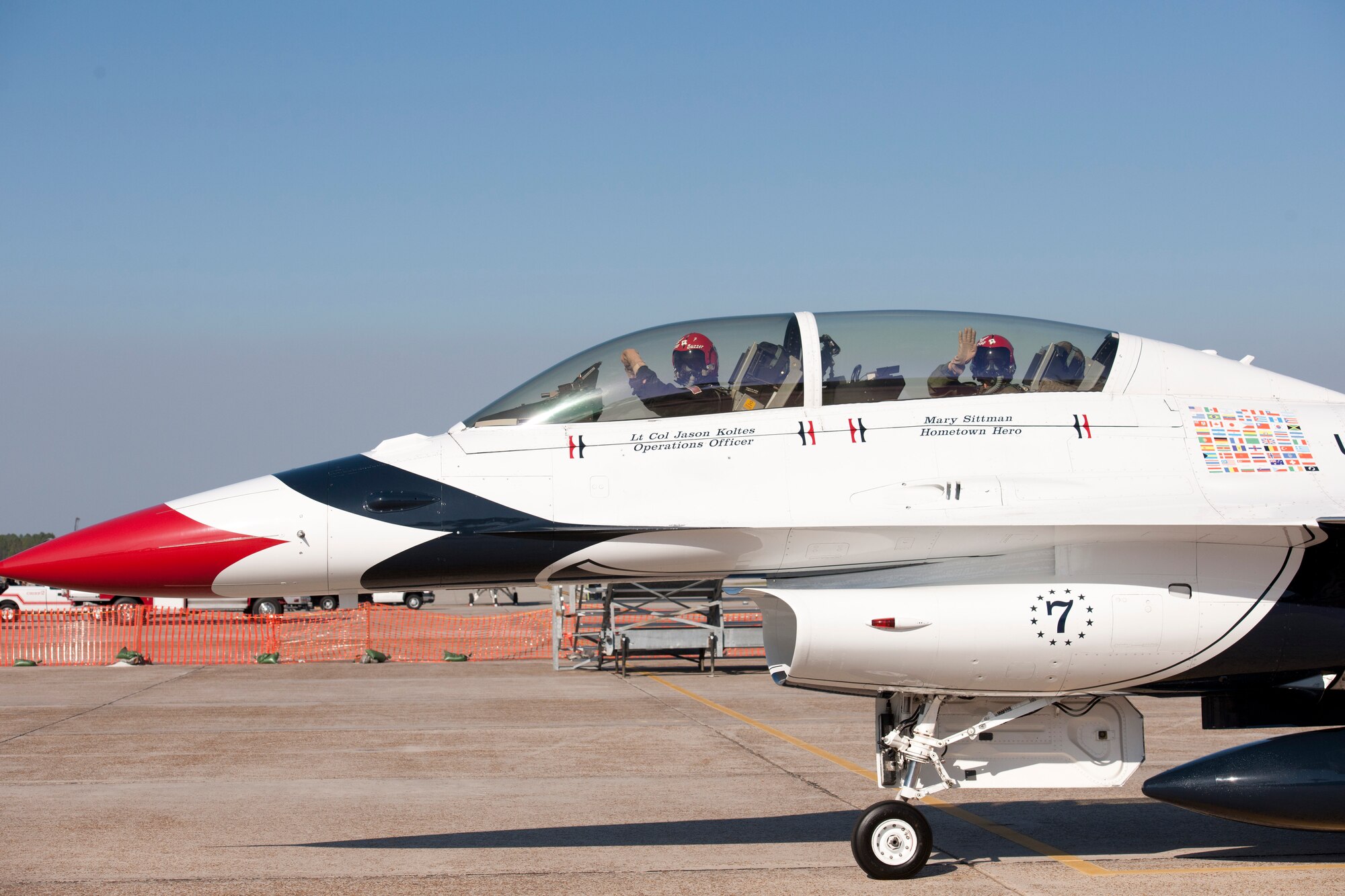 Lt. Col. Jason Koltes, Thunderbird number seven, signals to the crew chief as he prepares to take off, while Mary Sittman, 2011 Hometown Hero, waves to her family watching from the ramp. (U.S. Air Force photo by Jonathan Gibson)