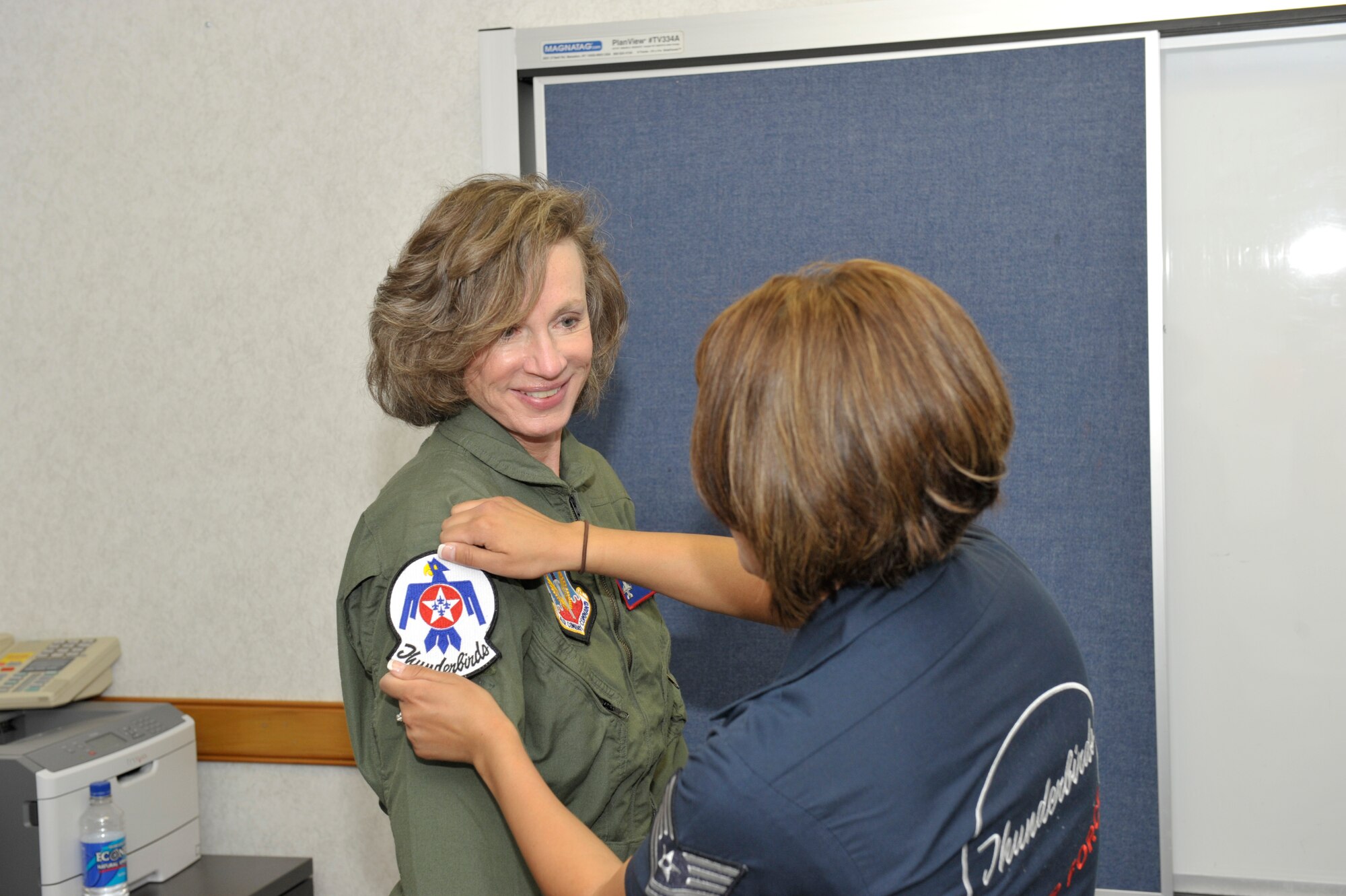 Life support specialist, Tech. Sgt. Amber Alumpe, places the Thunderbird patch on Mary's flightsuit prior to her flight in the F-16 March 24. Mary was awarded the flight as this year's air show Hometown Hero, for her work with Angel Flight, Inc. (U.S. Air Force photo by Jonathan Gibson)