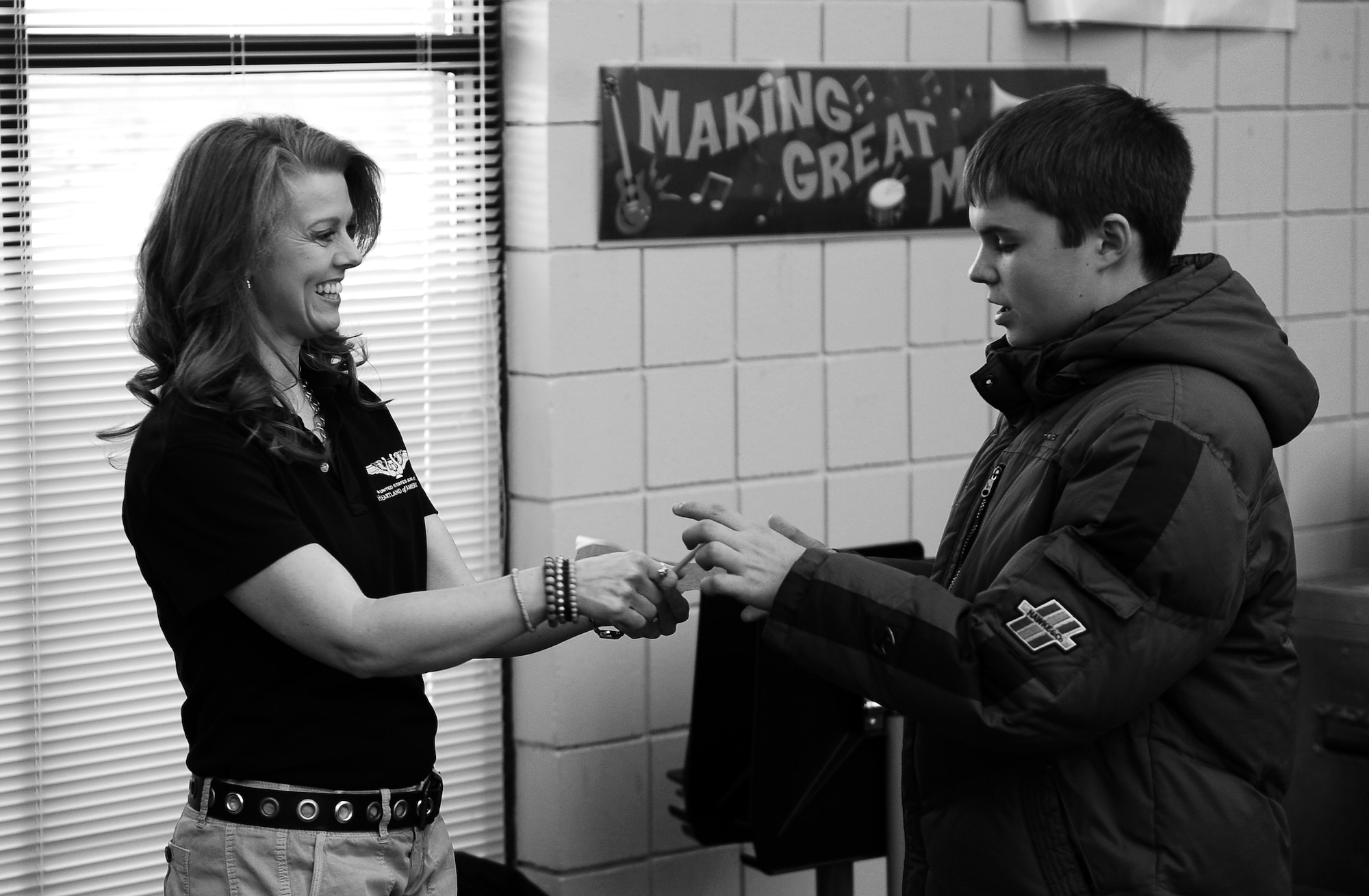 OFFUTT AIR FORCE BASE, Neb. - Tech. Sgt. Krista Joyce, the vocalist with the Heartland of America Band's Noteables jazz ensemble, signs an autograph for a young man following a two-part concert held at the Waukee Middle School in Waukee, Iowa, March 25. The Noteables perform at several venues with audiences ranging from small children to war veterans. U.S. Air Force photo by Josh Plueger (released)