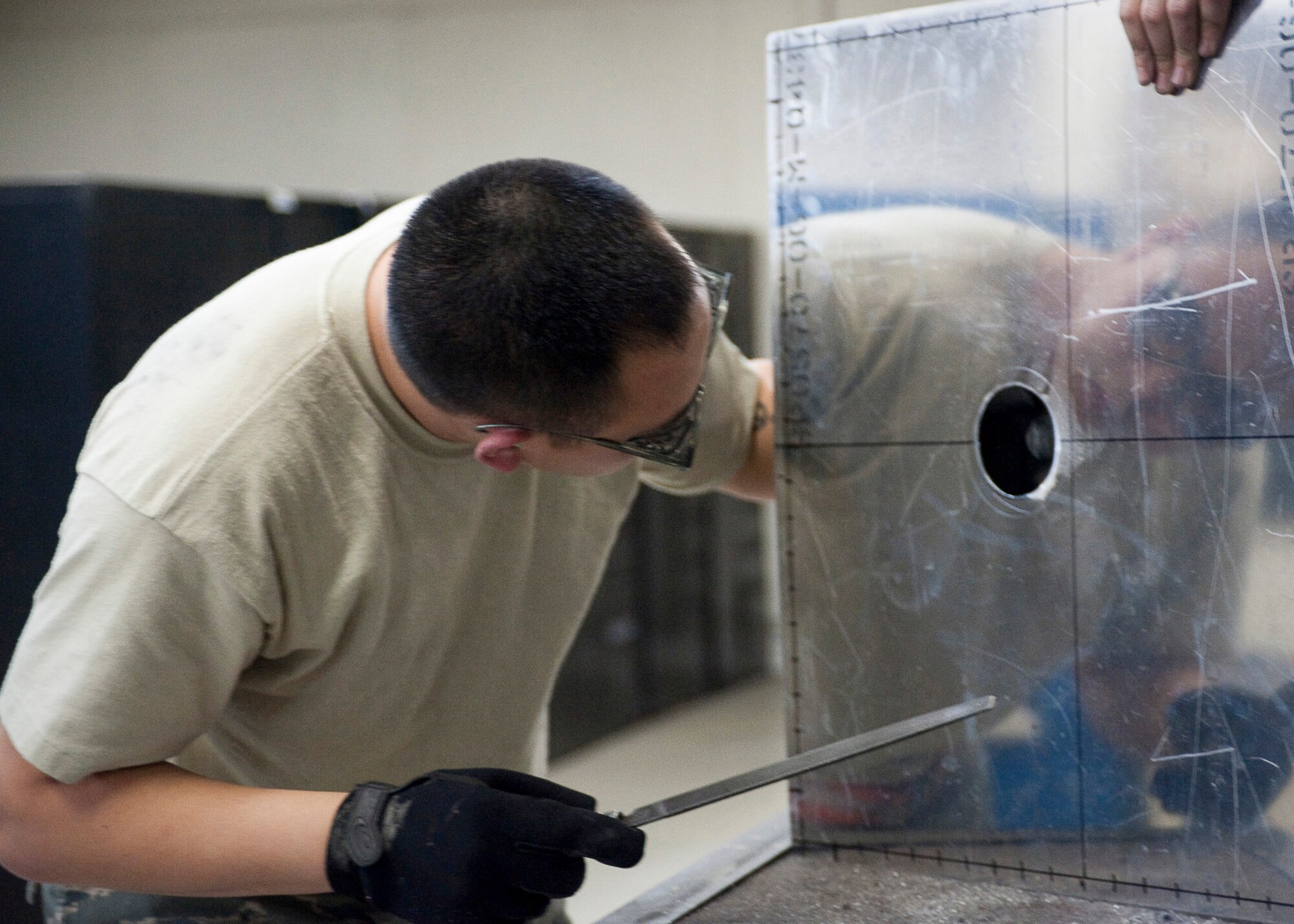 Senior Airman Thompson Kongmany examines his work March 28, 2011, at Yokota Air Base, Japan. Yokota AB maintainers built a mount that will be used to help gather data at the Fukushima nuclear plant. In support of disaster relief efforts, Yokota's aircraft structural maintenance Airmen have used their design and fabrication skills. Kongmany is a 374th Maintenance Squadron metals technician. (U.S. Air Force photo/Airman 1st Class Andrea Salazar)