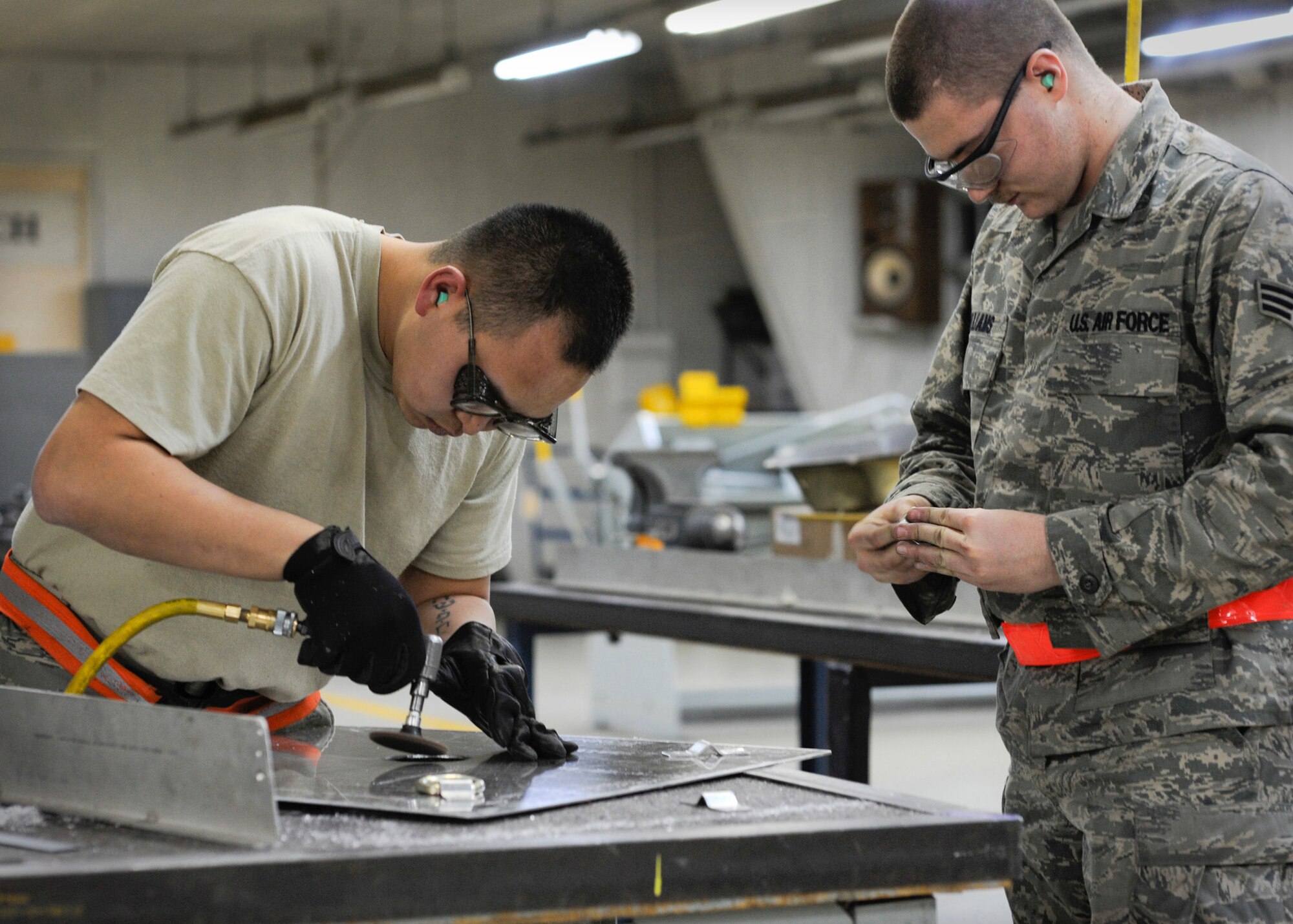 Senior Airmen Thompson Kongmany and Mark Williams create a camera mount March 28, 2011, at Yokota Air Base, Japan. Maintainers were tasked to create a mount for equipment to monitor radiation levels near reactors at the Fukushima nuclear plant. Kongmany and Williams are 374th Maintenance Squadron metal technicians. (U.S. Air Force photo/Airman 1st Class Andrea Salazar)
