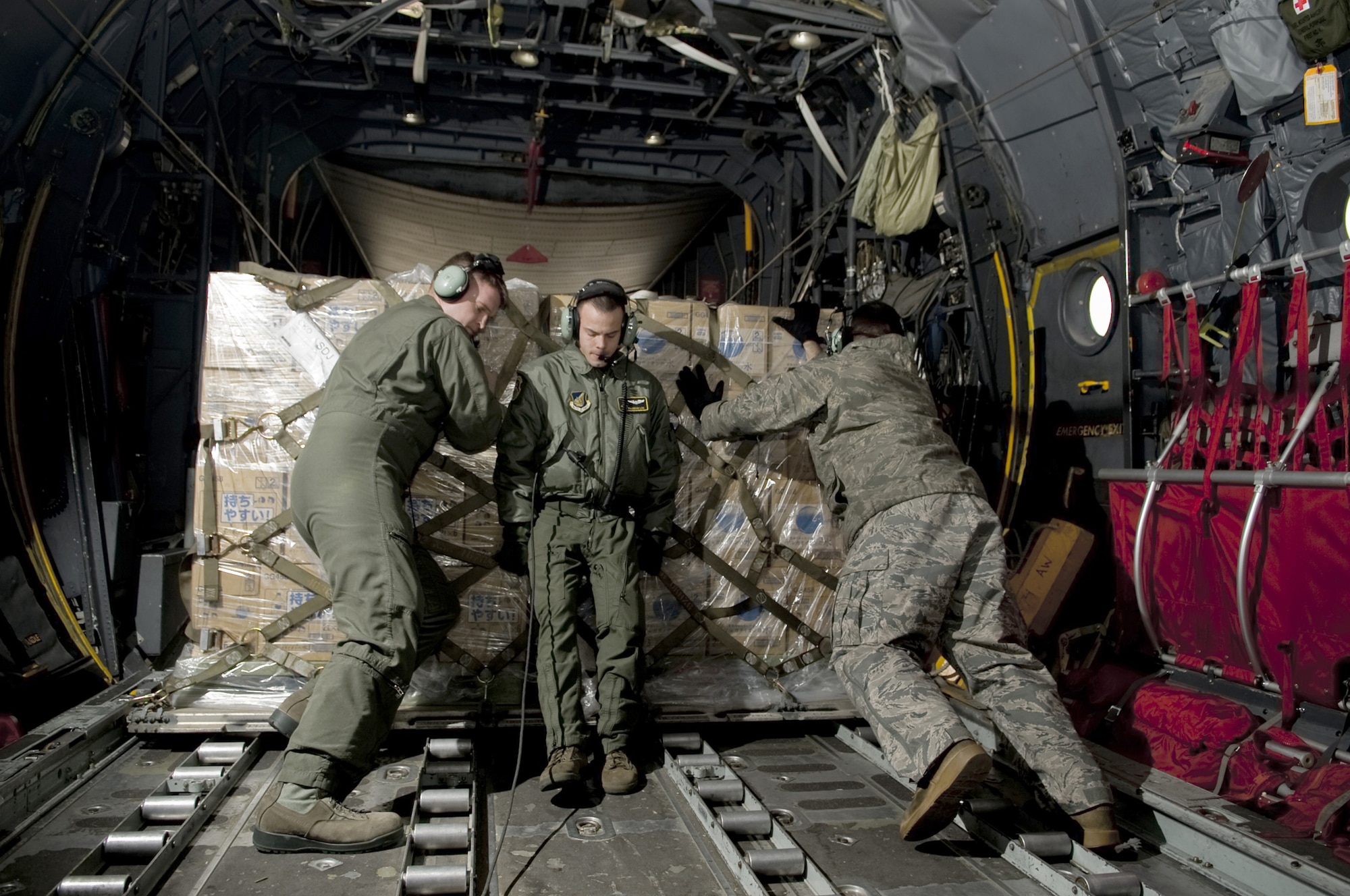 Airmen from the 36th Airlift Squadron push a pallet off a C-130H Hurcules March 26, 2011, at Sendai Airport, Japan.  (U.S. Air Force photo by/Master Sgt. Jeromy K. Cross)