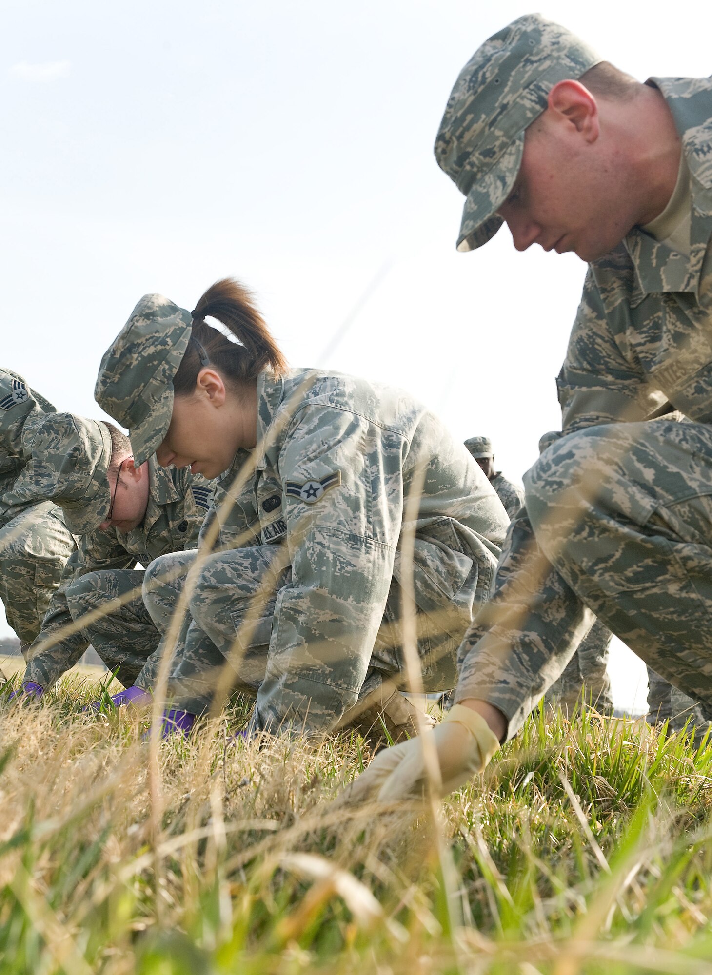 Airmen 1st Class Theresa Ward and Eric Bates,436th Force Support Squadron,  sweep throgh grass during a Search and Recovery training exercise here in conjunction with Air Force Mortuary Affairs Operations March 22, 2011. (U.S. Air Force photo/Roland Balik)
