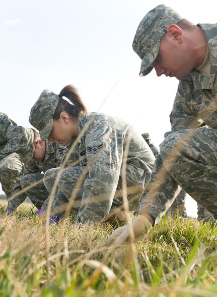 Airmen 1st Class Theresa Ward and Eric Bates,436th Force Support Squadron,  sweep throgh grass during a Search and Recovery training exercise here in conjunction with Air Force Mortuary Affairs Operations March 22, 2011. (U.S. Air Force photo/Roland Balik)