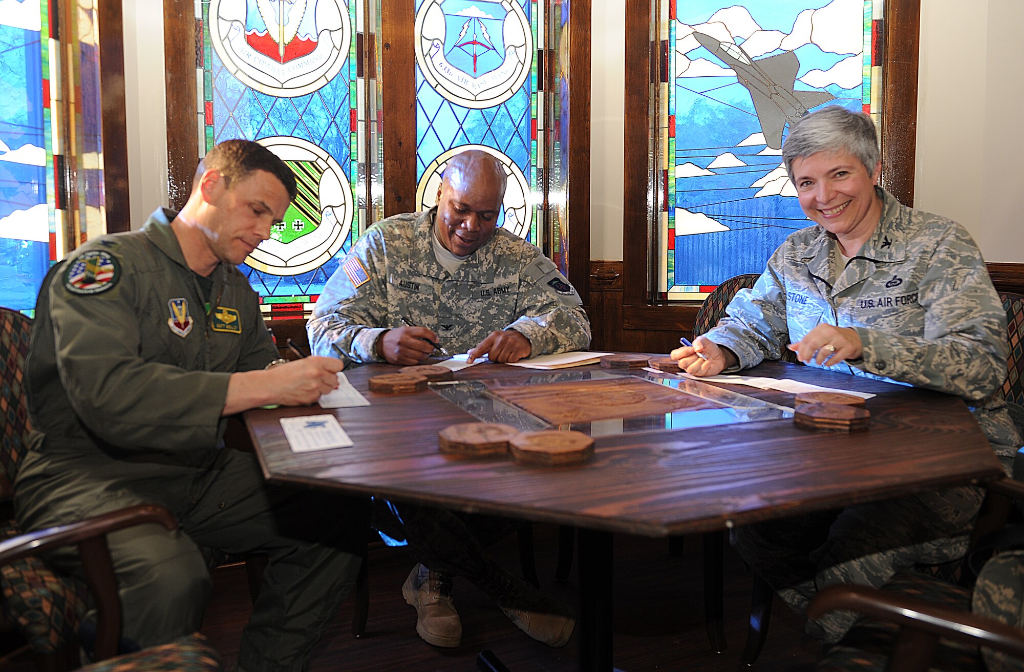 Col. Matthew Malloy 1st Fighter Wing commander, Army Col. Reggie Austin 633d Air Base Wing vice commander, and Col. Christina Stone 480th Intelligence Surveillance Reconnassiance Wing vice commander donate to the Air Force Assistance Fund during the kickoff event at the Officer's Club at Langley Air Force Base, Va., March 28, 2011. The AFAF is an annual fundraiser dedicated to raising money for the charitable affiliates that provide support to Air Force families in need. (U.S. Air Force photo by Senior Airman Antoinette Gibson/Released)