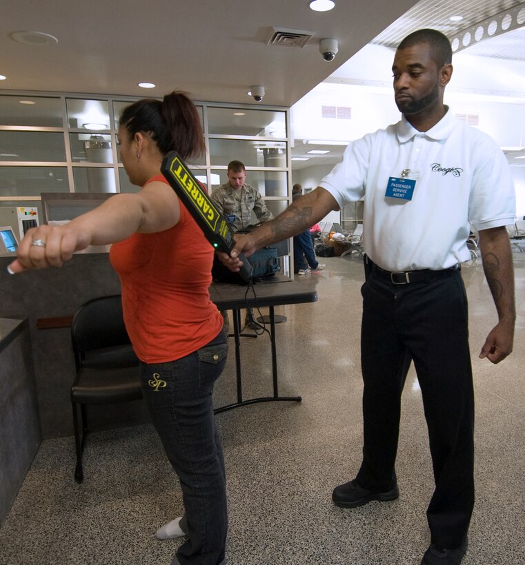 Reggie Perkins, 89th Aerial Port Squadron passenger service agent, uses a metal detector wand to inspect a passenger during a body search at the security point inside the Andrews passenger terminal. (Photo by Bobby Jones)