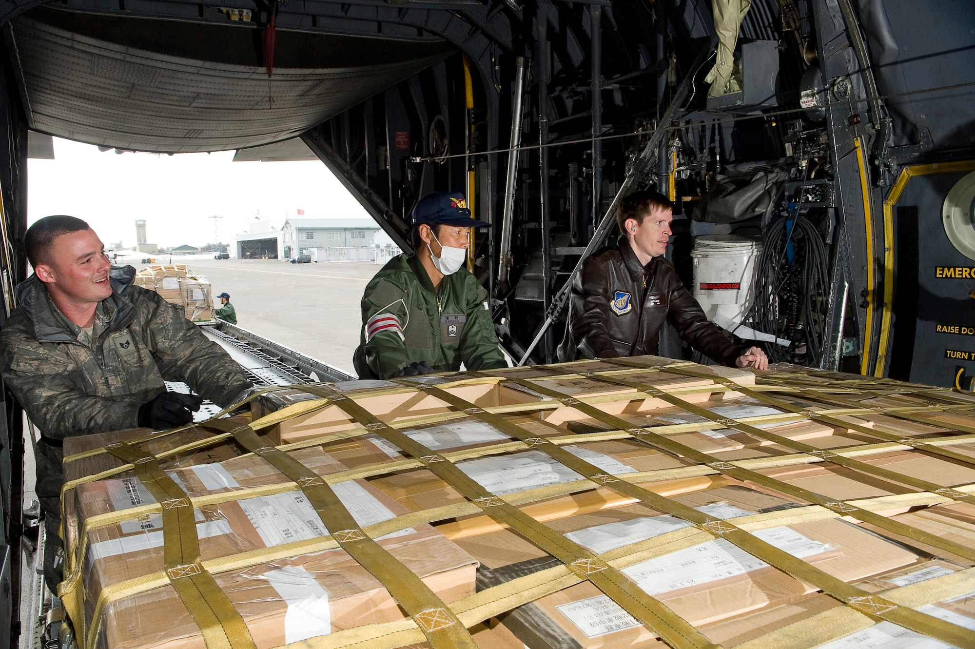 CHITOSE AIR BASE, Japan -- U.S. Air Force Staff Sgt. Steven Sheeley (left), Capt Eric Elmore (right), 36th Airlift Squadron, and a member from the Japanese Defense Force, push a pallet onto a C-130 at Chitose Air Base, March 29. The C-130 will deliver humanitarian goods and supplies to the Japanese Defense Force in support of Operation Tomodachi. (U.S. Air Force photo by/Master Sgt. Jeromy K. Cross)





