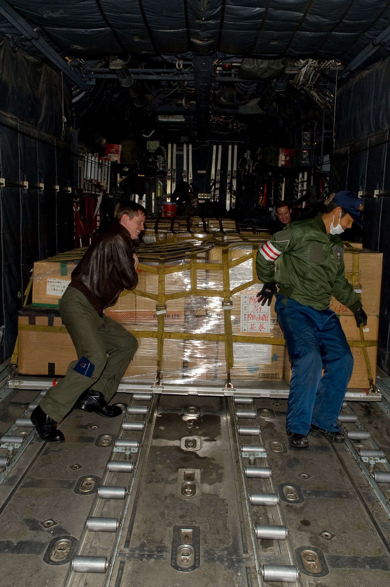 CHITOSE AIR BASE, Japan -- U.S. Air Force Capt. Eric Elmore, 36th Airlift Squadron, and a member of the Japanese Defense Force, push a pallet onto a C-130 at Chitose Air Base, March 29. Because of Yokota's long-standing working relationship with Japanese forces, Airmen are able to rapidly respond with critically needed supplies and capabilities in times of crisis. (U.S. Air Force photo by/Master Sgt. Jeromy K. Cross)






