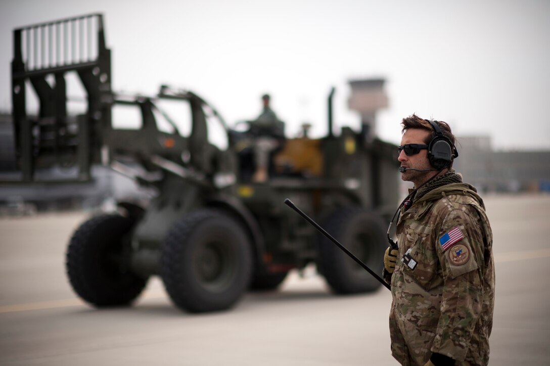 The 320th Special Tactics Squadron airfield commander directs the offload of the first C-17 Globemaster III, also the first jet aircraft, to land at Sendai Airport following the March 11 earthquake and tsunami that covered most of the flightline with debris. (U.S. Air Force photo/Staff Sgt. Samuel Morse)