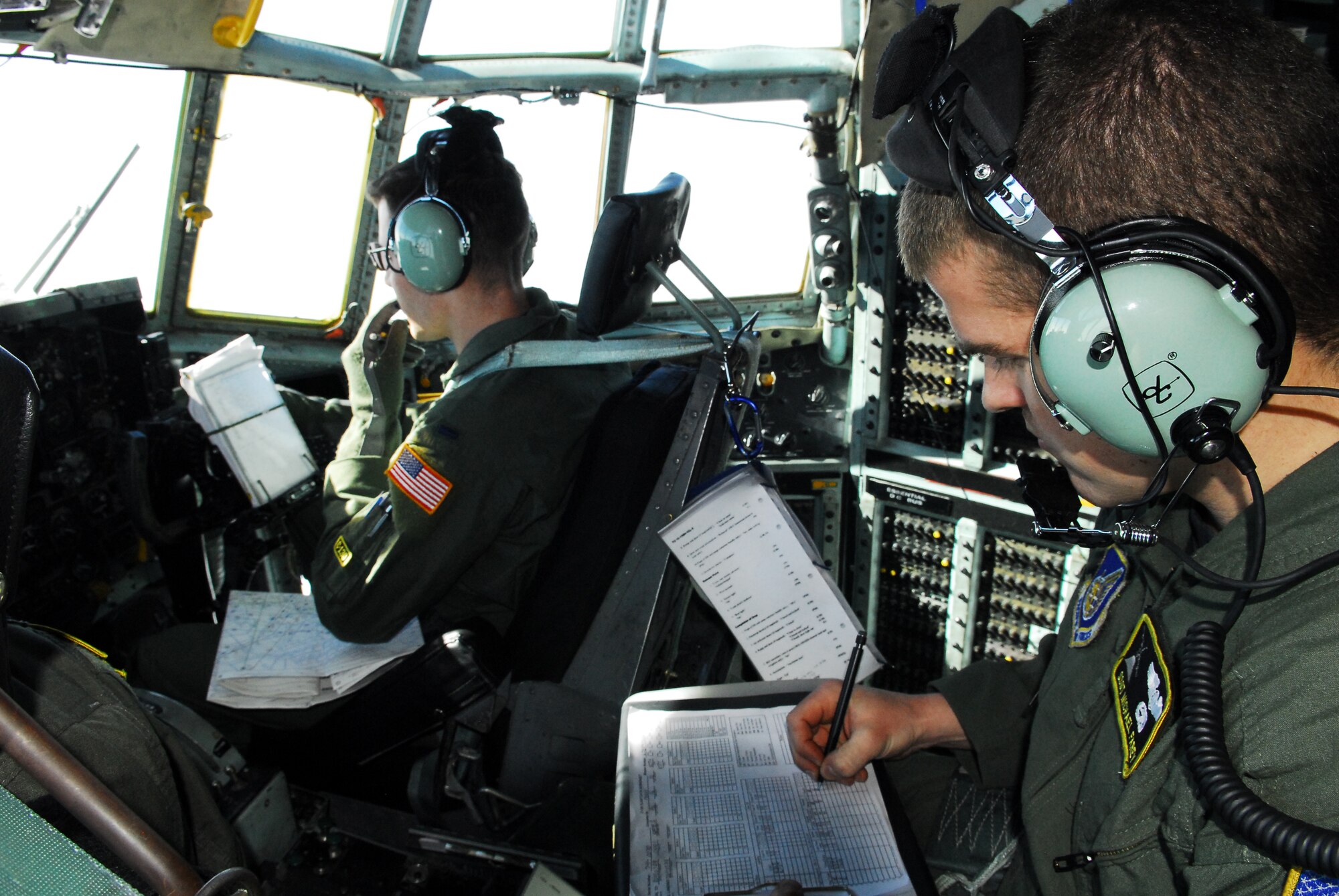 YOKOTA AIR BASE, Japan -- 1st Lt. Christopher Baisch (left), a C-130 co-pilot, and Staff Sgt. Michael Farey, a C-130 flight engineer, from the 36th Airlift Squadron, discuss flight information during a mission from Matsushima Air Base, Japan, to Yokota, March 29. Lieutenant Baisch, a native of Selden, N.Y., and Sergeant Farey, a native of Albany, Ore., were part of a team from Yokota that delivered more than 11,000 pounds of humanitarian relief supplies at the request of the Government of Japan. (U.S. Air Force photo/Staff Sgt. Robin Stanchak)