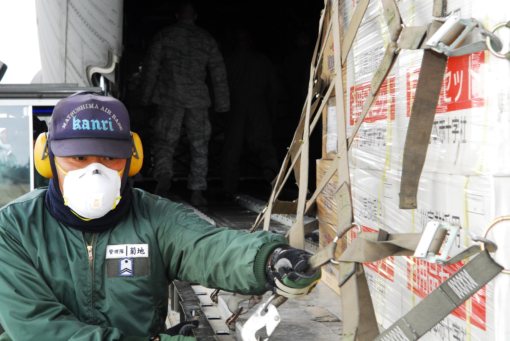 MATSUSHIMA AIR BASE, Japan -- A servicemember from Matsushima Air Base, downloads relief supply pallets from a C-130, March 29. Members from the 36th Airlift Squadron, Yokota Air Base, transported more than 11,000 pounds of  humanitarian supplies from Chitose Air Base to Matsushima as part of Operation Tomodachi. (U.S. Air Force photo/Staff Sgt. Robin Stanchak)