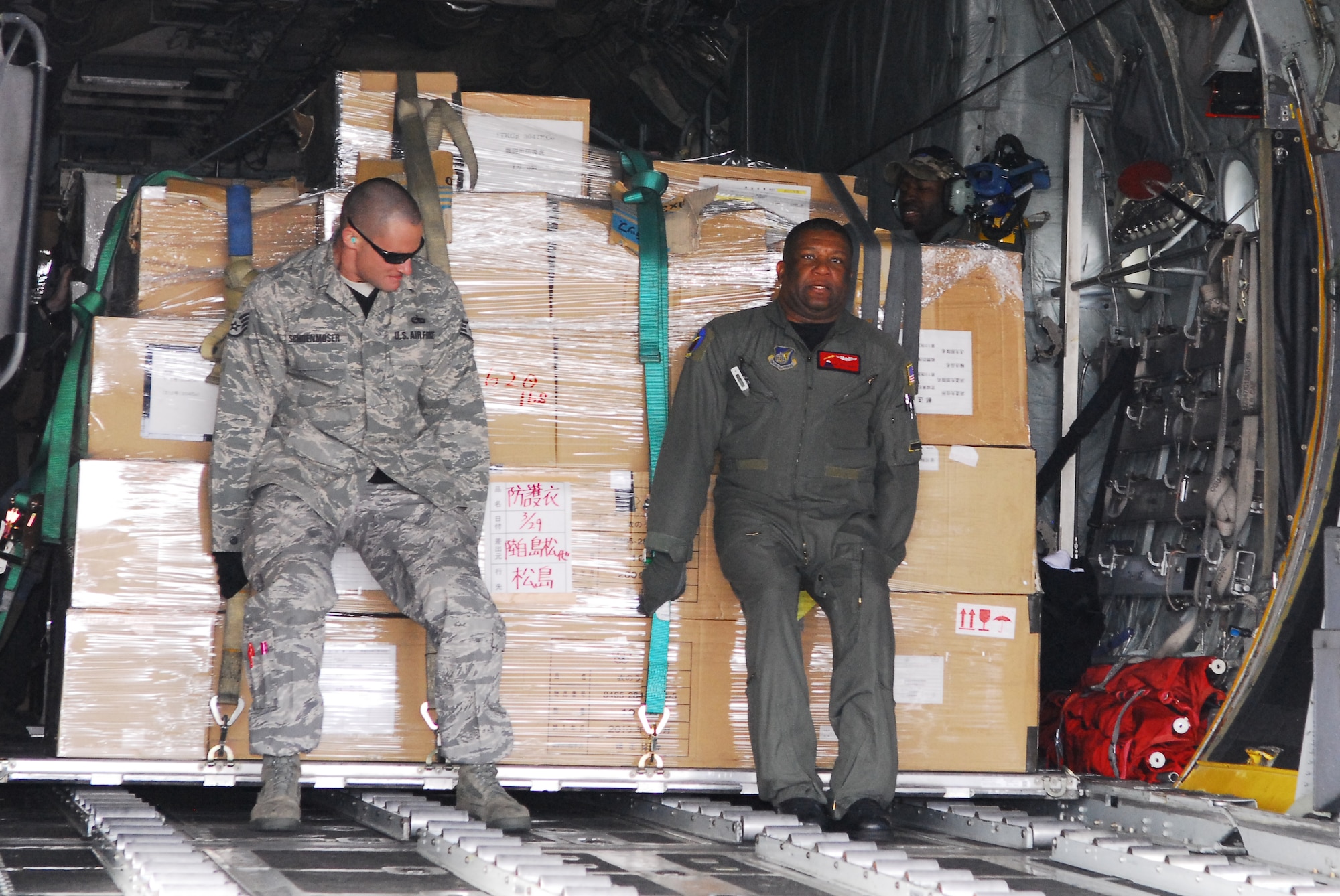 MATSUSHIMA AIR BASE, Japan -- Staff Sgt. Tyson Schoenmoser (left), 374th Aircraft Maintenance Squadron crewchief, and Master Sgt. Anthony Pemberton, 36th Airlift Squadron C-130 loadmaster, download pallets carrying more than 11,000 pounds of relief supplies at Matsushima Air Base, Japan, March 29. The U.S. military is fully committed to supporting the Government of Japan's request for humanitarian assistance. (U.S. Air Force photo/Staff Sgt. Robin Stanchak)