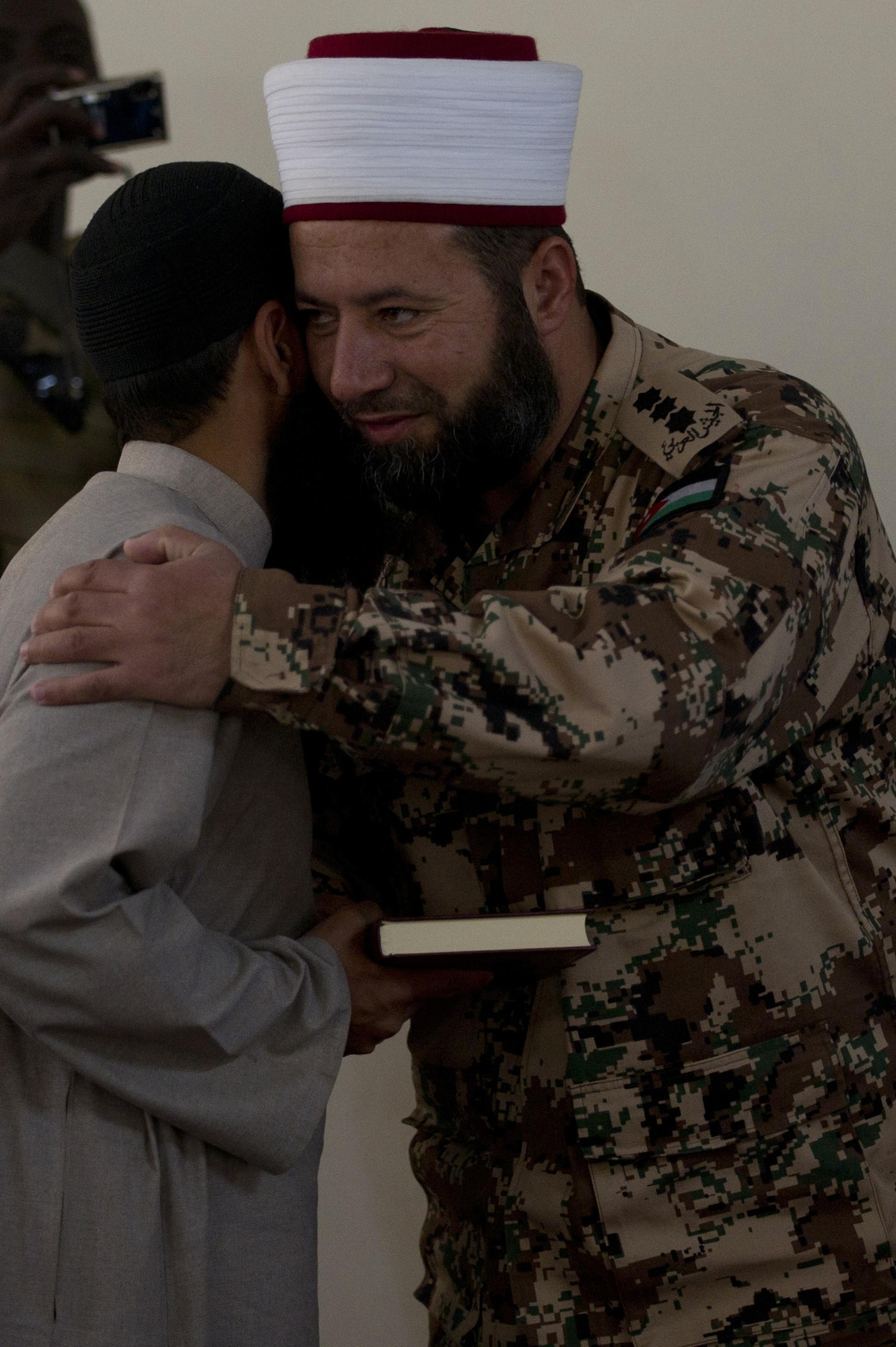 Al-Qudah Sabri, a Jordanian Islamic Imam, and Asim Hafiz, United Kingdom Armed Forces Islamic Imam, embrace after speaking in Qalat City, Afghanistan, during a Mullah Shura. The Mullah Shura was a meeting of religious leaders in the Zabul province used to discuss how they can use religion to help resolve violence and fighting in Afghanistan. Imam Al-Qudah Sabri and Aim Hafiz were guest speakers at the event. (U.S. Air Force photo by Master Sgt. Adrian Cadiz)