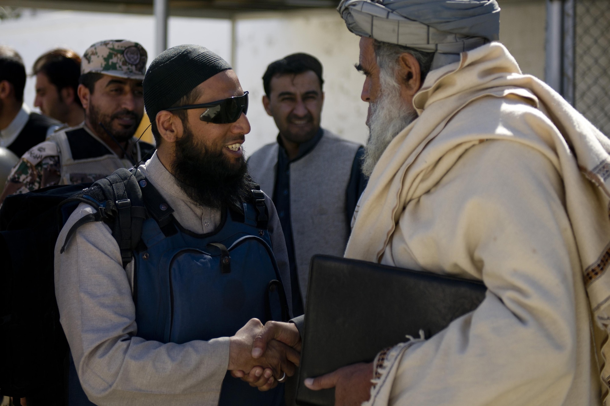 Asim Hafiz, United Kingdom Armed Forces Islamic Imam, greets a Zabul province government official in Qalat City, Afghanistan, prior to the start of a Mullah Shura. The Mullah Shura was a meeting of religious leaders in the Zabul province used to discuss how they can use religion to help resolve violence and fighting in Afghanistan. Imam Aim Hafiz was a guest speaker at the event. (U.S. Air Force photo by Master Sgt. Adrian Cadiz)
