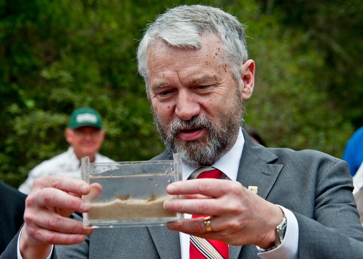 Rowan Gould, director of U.S. Fish and Wildlife Service, takes a look at  a container of Okaloosa darters March 28 at Eglin Air Force Base, Fla.  The small fish, whose habitat is almost exclusively on the Eglin ranges, became the first-ever fish on DoD lands to be reclassified on the endangered species list.  It remains in the “threatened” status, but due to major erosion control efforts by 96th Civil Engineer Group’s Natural Resources Management Section and the U.S. Fish and Wildlife Service the population has tripled since 1995, bringing the species back from the brink of extinction.  (U.S. Air Force photo/ Samuel King Jr.)
 