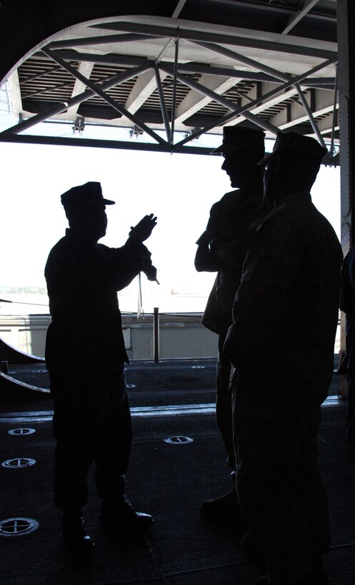 Brigadier General Christopher S. Owens, middle, II Marine Expeditionary Force deputy commanding general, receives a brief on the operations of USS Bataan’s hangar bay during his tour of the ship March 29, 2011.  Owens toured USS Bataan as the 22nd Marine Expeditionary Unit prepares to leave nearly three month early for their deployment in support of U.S., Africa, European and Central Commands.  The 22nd MEU is currently conducting pre-deployment training exercises with Amphibious Squadron 6, and is embarked aboard the USS BATAAN Amphibious Ready Group.  The 22nd MEU is a multi-mission capable Marine Air Ground Task Force comprised of Aviation Combat Element, Marine Medium Tilt Rotor Squadron 263 (Reinforced); Logistics Combat Element, Combat Logistics Battalion 22; Ground Combat Element, Battalion Landing Team, 2nd Battalion, 2nd Marine Regiment; and its command element.
