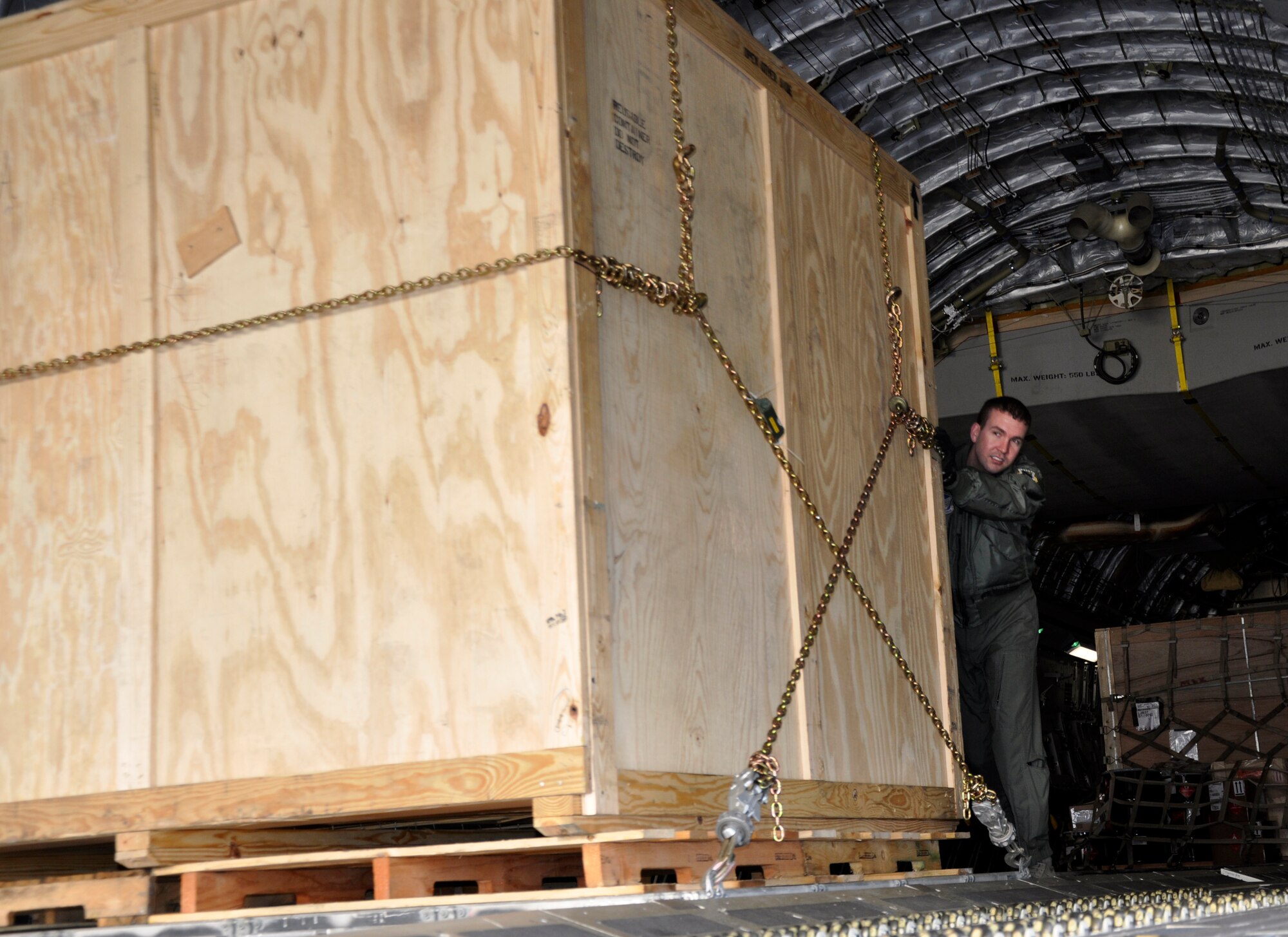 MISAWA AIR BASE, Japan – Capt. Derek Dupuis, 517th Airlift Squadron C-17 Globemaster pilot assigned to Joint-Base Elmendorf Richardson, Alaska, pushes a crate of supplies down the aircraft’s cargohold at the flightline March 27, 2011. The supplies will be used in support of Operation Tomodachi. (U.S. Air Force photo by Senior Airman Joe W. McFadden / RELEASED) 