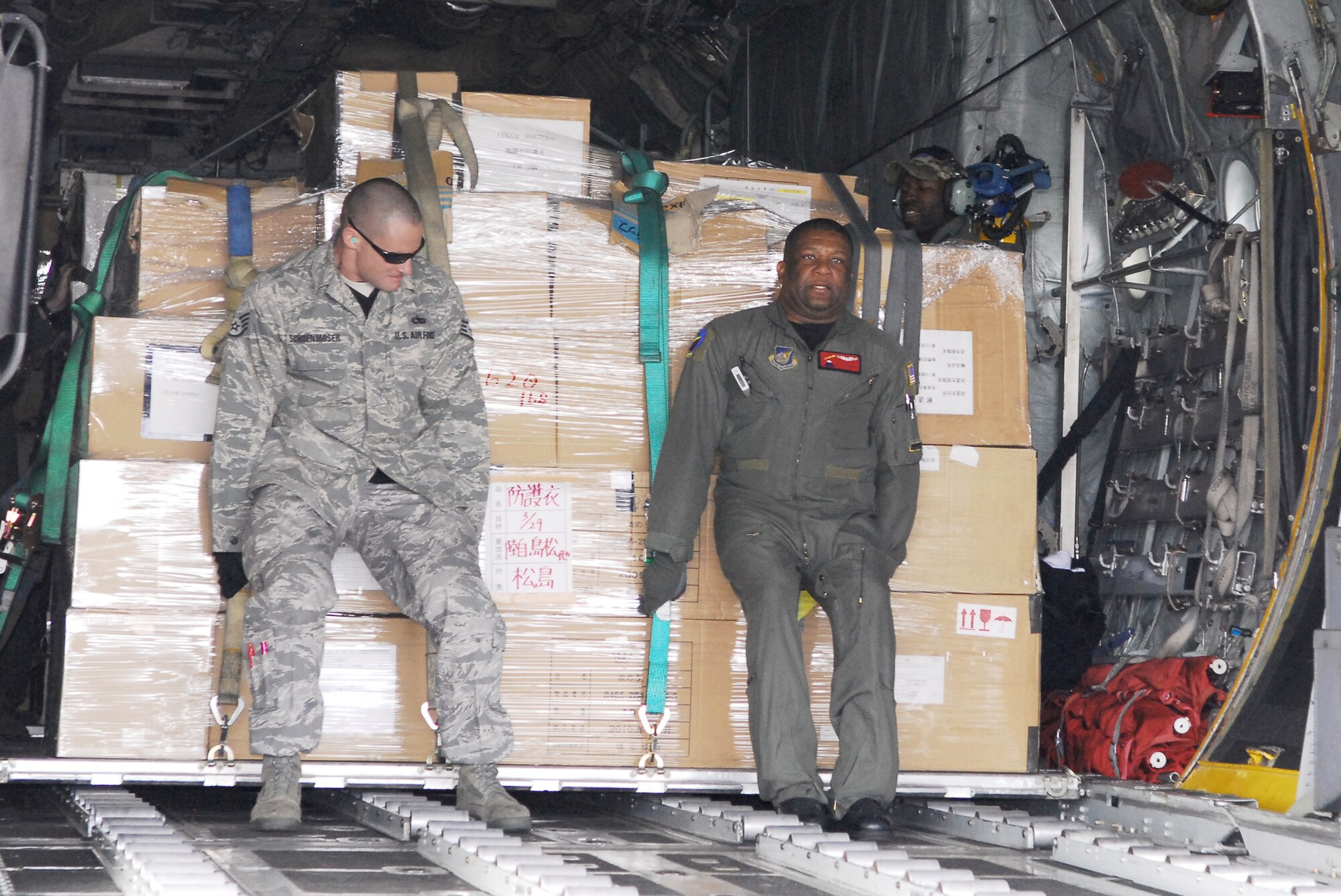 Staff Sgt. Tyson Schoenmoser (left) and Master Sgt. Anthony Pemberton off-load pallets carrying more than 11,000 pounds of relief supplies March 29, 2011, at Matsushima Air Base, Japan. Schoenmoser is a crew chief assigned to the 374th Aircraft Maintenance Squadron at Yokota Air Base, Japan. Pemberton is a loadmaster assigned to the 36th Airlift Squadron at Yokota Air Base, Japan. (U.S. Air Force photo/Staff Sgt. Robin Stanchak)