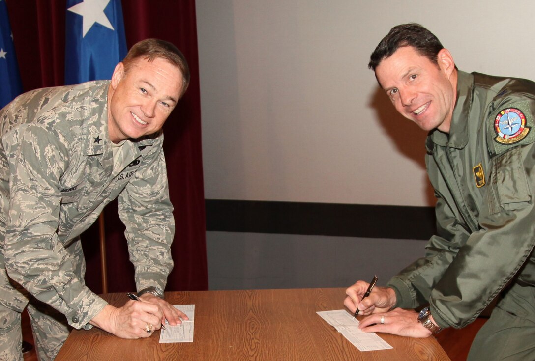 Brig. Gen. Darryl Burke (left), 82nd Training Wing commander, and Col. George Menker (right), 80th Flying Training Wing vice commander, sign their Air Force Assistance Fund forms March 29 at the AFAF kickoff event, at the base theater. Contributions made to the AFAF help support Airmen through the Air Force Aid Society, Air Force Enlisted Village, Air Force Villages and the LeMay Foundation. Sheppard’s fundraising cycle began March 28 and will continue through May 6, with a total goal of raising $91,643. (U.S. Air Force photo/Adawn Kelsey) 
