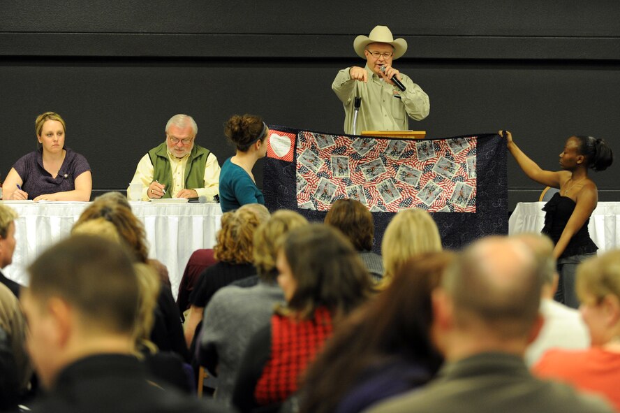MINOT AIR FORCE BASE, N.D. -- Mr. John Beardman, auctioneer for the 25th Annual Prairie Warrior Association Auction held at the Holiday Inn-Riverside Hotel here March 26, auctions off a 9-11 commemorative quilt donated by the 91st Missile Security Forces Squadron. The auction is an annual, community-based event designed to bring members of Team Minot together and raise funds in support of military servicemembers stationed at Minot Air Force Base. (U.S. Air Force photo/Airman 1st Class Jose L. Hernandez)