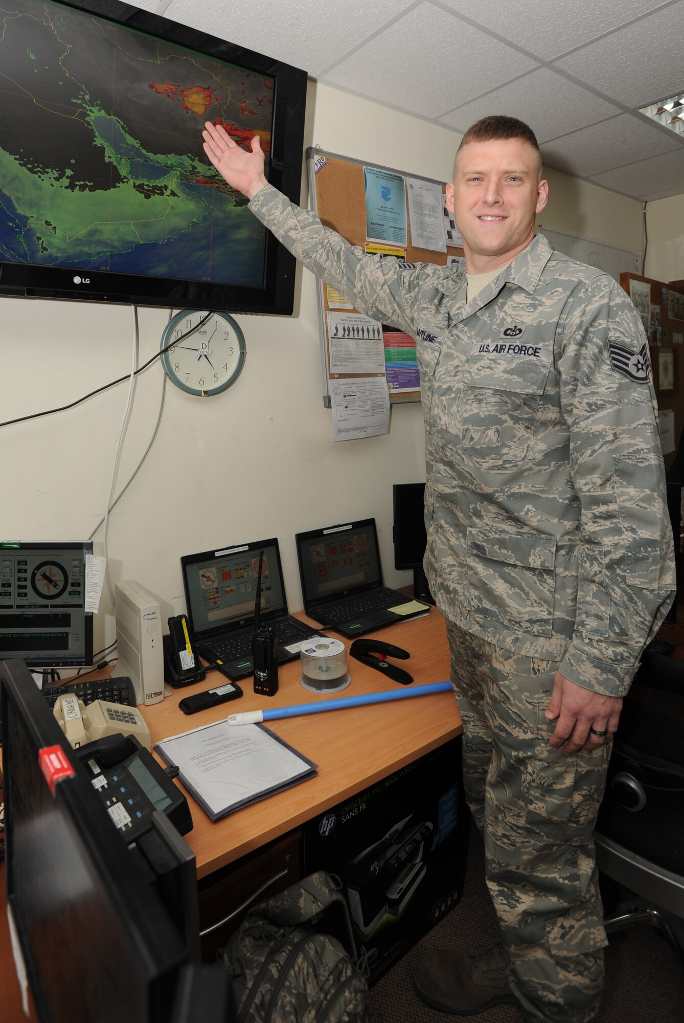 SOUTHWEST ASIA -- Staff Sgt. Joshua Hartline shows off his work center and weather maps of the local area. Sergeant Hartline is a weather forecaster from Scott Air Force Base’s 375th Operations Support Squadron, deployed with the 380th Expeditionary Operations Support Squadron Weather Flight. (Courtesy Photo)