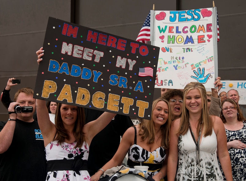 Mrs. Padgett and friends hold up a sign during a homecoming ceremony for Senior Airman Todd Padgett, 23rd Aircraft Maintenance Squadron crew chief, who's coming home to a newborn baby at Moody Air Force Base, Ga., March 29. Airman Padgett was deployed for six months to Kandahar, Afghanistan. (U.S. Air Force photo/Airman 1st Class Joshua Green)(RELEASED)