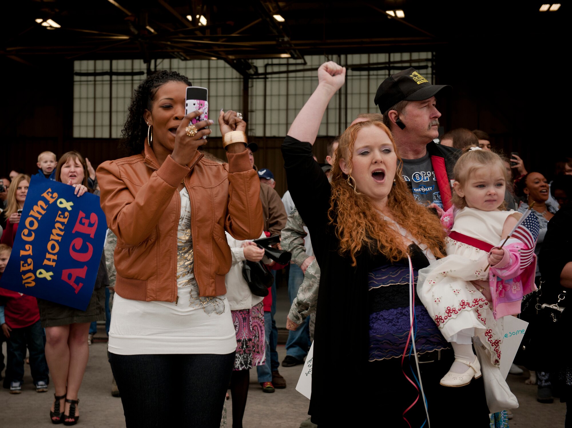 Two spouses cheer and yell at the sight of a bus holding Airmen returning from a six-month deployment at Moody Air Force Base, Ga., March 29. The Airmen returned from a deployment to Kandahar, Afghanistan. (U.S. Air Force photo/Airman 1st Class Joshua Green)(RELEASED)