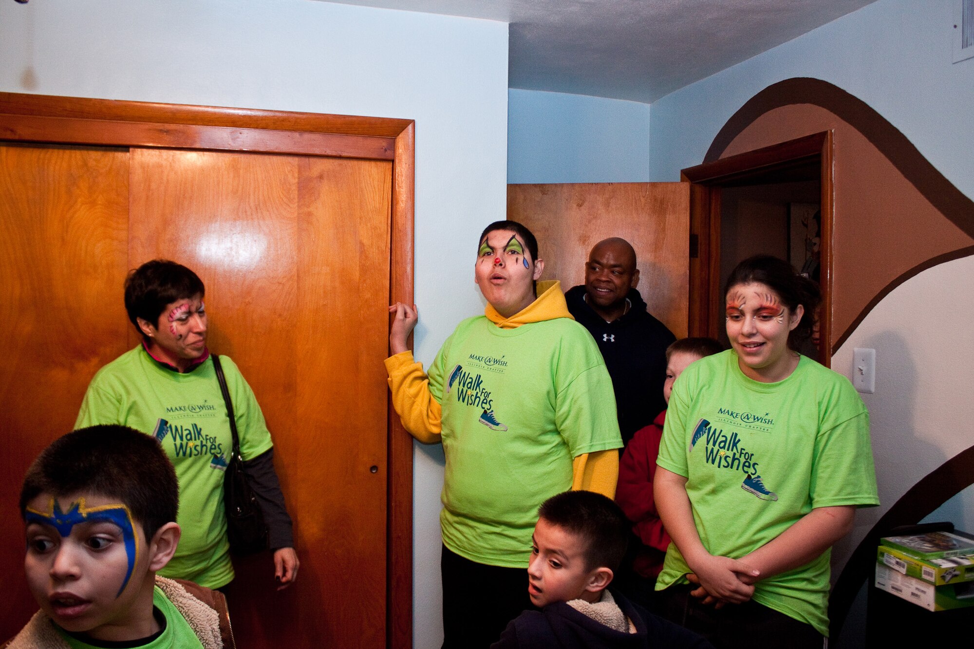 EAST ST. LOUIS, Ill. -- Juan Ortiz (center), 15, checks out his bedroom that was remodeled courtesy of the Make-a-Wish Foundation, including Scott volunteers. The volunteers painted the walls, put together new furniture, window treatments and hung a ceiling fan. (Courtesy Photo) 