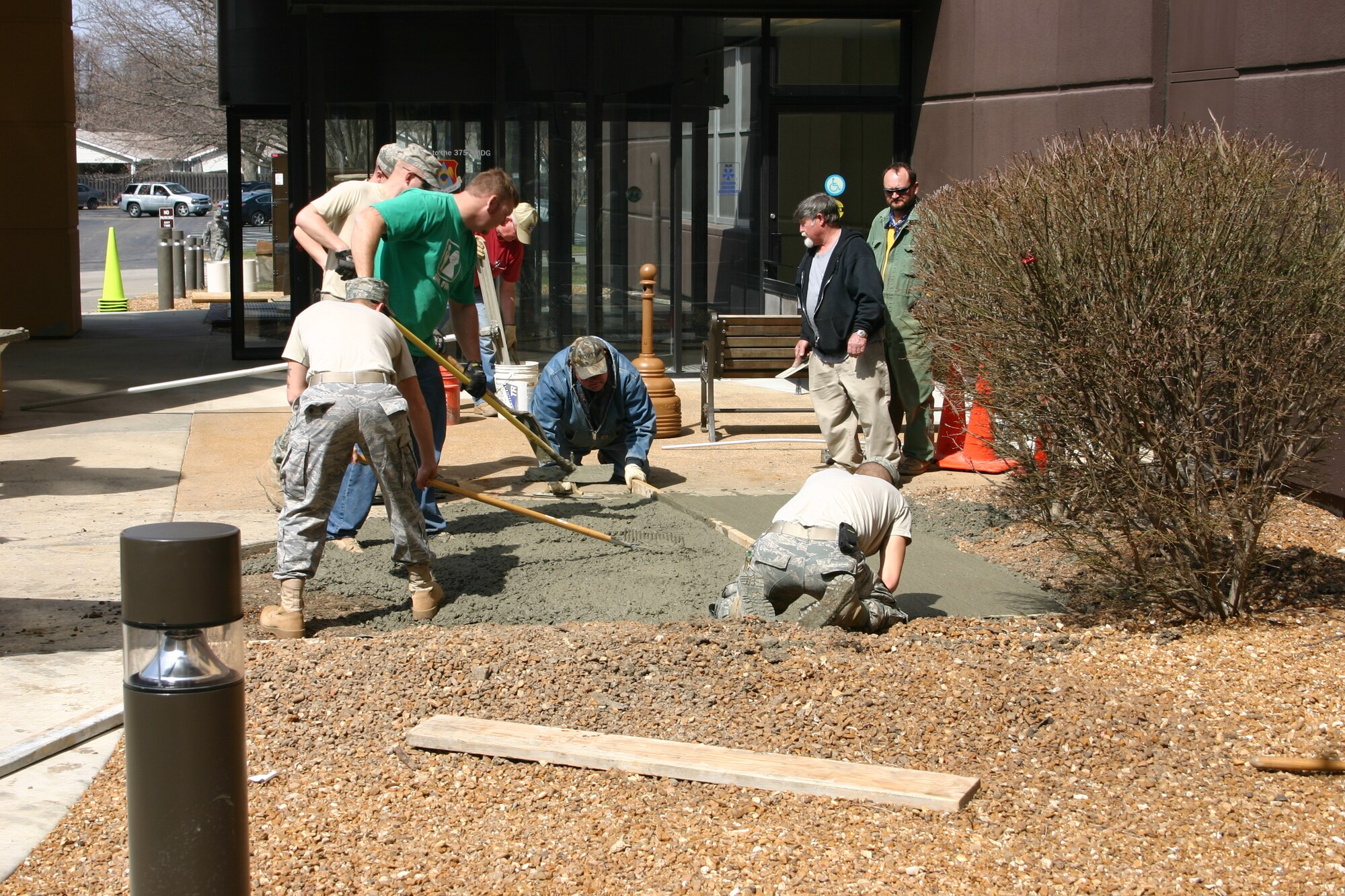 SCOTT AIR FORCE BASE, Ill. -- Members of the 375th Civil Engineer Squadron smooth cement while laying the foundation for a new bike rack at the Scott Clinic March 17, 2011. The bike rack is one of two installed on base in preperation for the base's celebration of Earth Week. (Courtesy Photo)