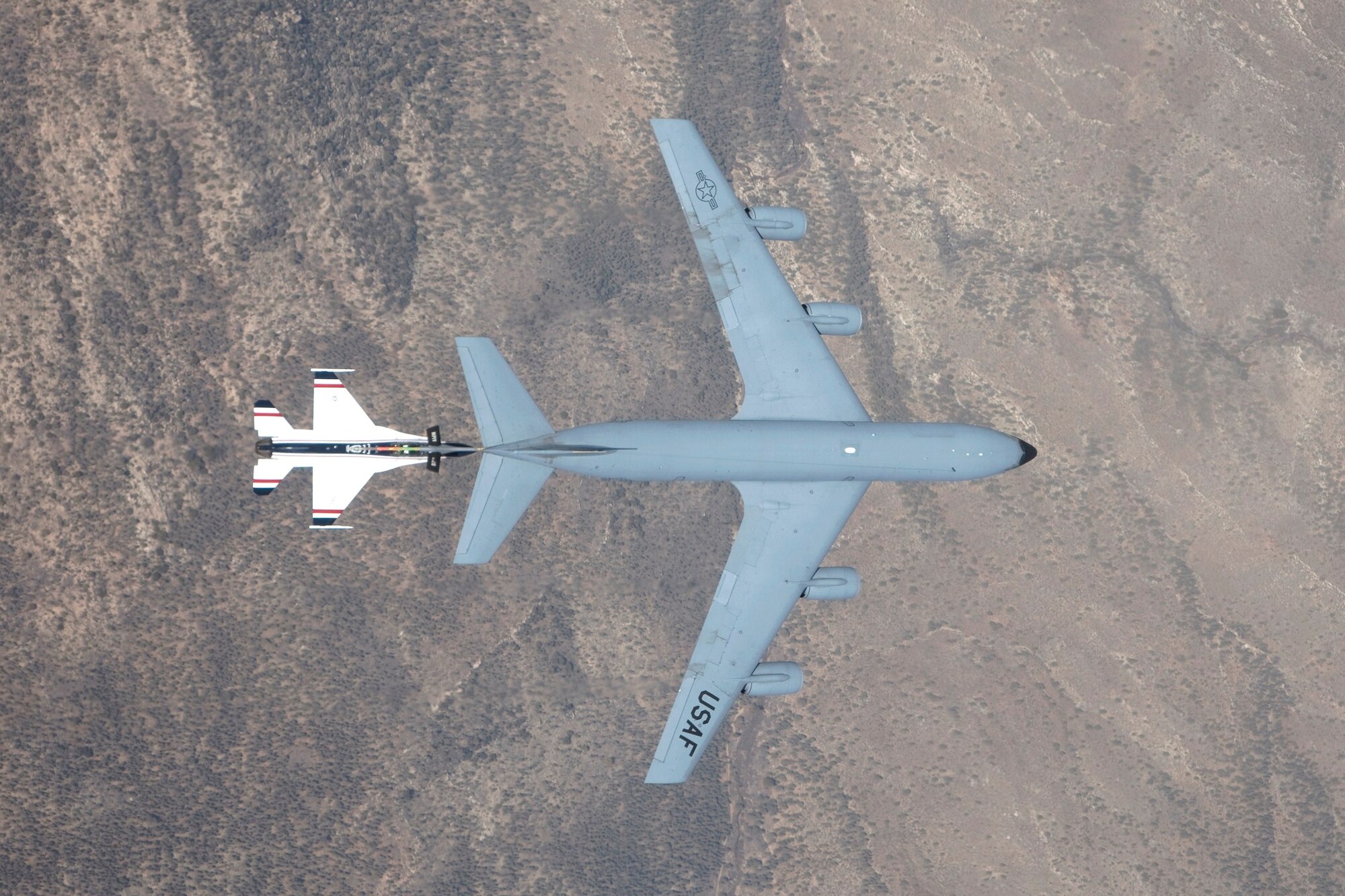 The United States Air Force Test Pilot School’s VISTA (Variable stability In-flight Simulator Test Aircraft) F-16 positions itself underneath a KC-135 refueler during a flight test mission conducted by TPS students March 17. The maneuver is part of the Basic Envelope Air Refueling Control Laws, or BEAR CLAW, test project, which is aimed at obtaining preliminary data leading ultimately to have an unmanned aerial vehicle conduct air-to-air refueling. (Air Force photo by Bobbi Zapka)