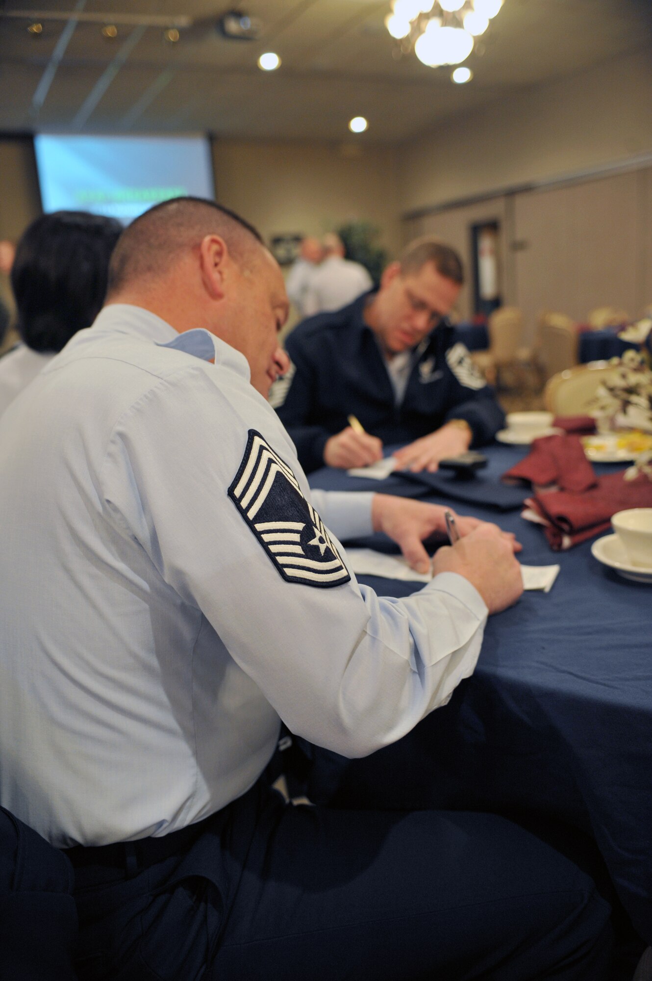 MINOT AIR FORCE BASE, N.D. -- Chief Master Sgt. Bryn LePine, 5th Mission Support Group command chief, and Chief Master Sgt. Kent Smith, 5th Bomb Wing command chief, fill out their Air Force Assistance Fund forms at the campaign kickoff breakfast, here March 28. The AFAF was established to raise funds for the charitable organizations that provide support for active duty, retirees, reservists, guardsmen and their dependents, including surviving spouses in need. This year’s campaign will run for six weeks from March 28 through May 6. (U.S. Air Force photo/Staff Sgt. Keith Ballard)