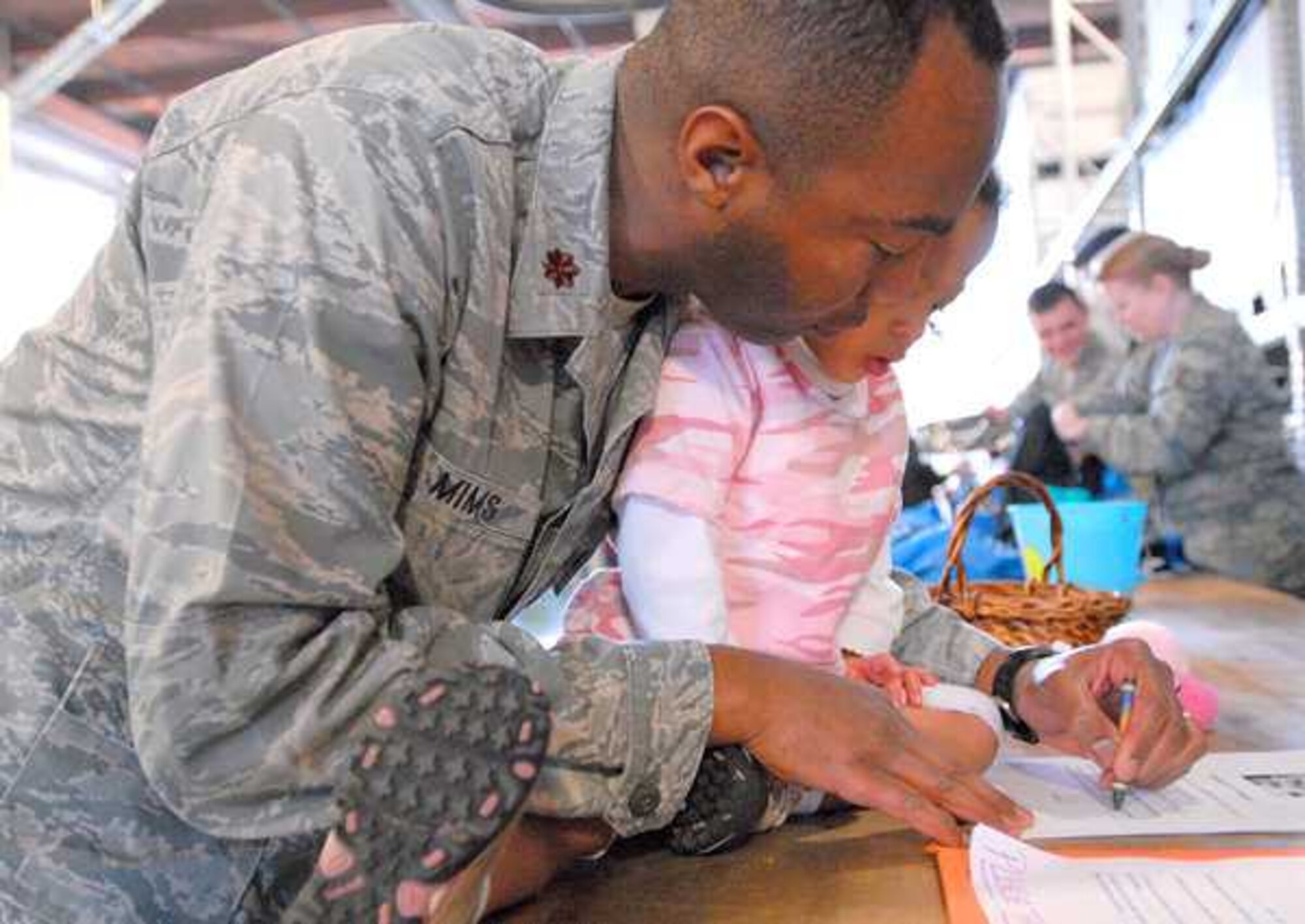 Maj. Anthony Mims, 627th Logistics Readiness Squadron commander, helps his daughter, Cecilia, complete the Power of Attorney paperwork authorizing SpongeBob SquarePants to oversee her affairs while she is "deployed," as part of the 627th LRS's Deployment Faire March 19, 2011, at McChord Field, Joint Base Lewis-McChord, Wash. (U.S. Air Force courtesy photo/Julie Blakely)