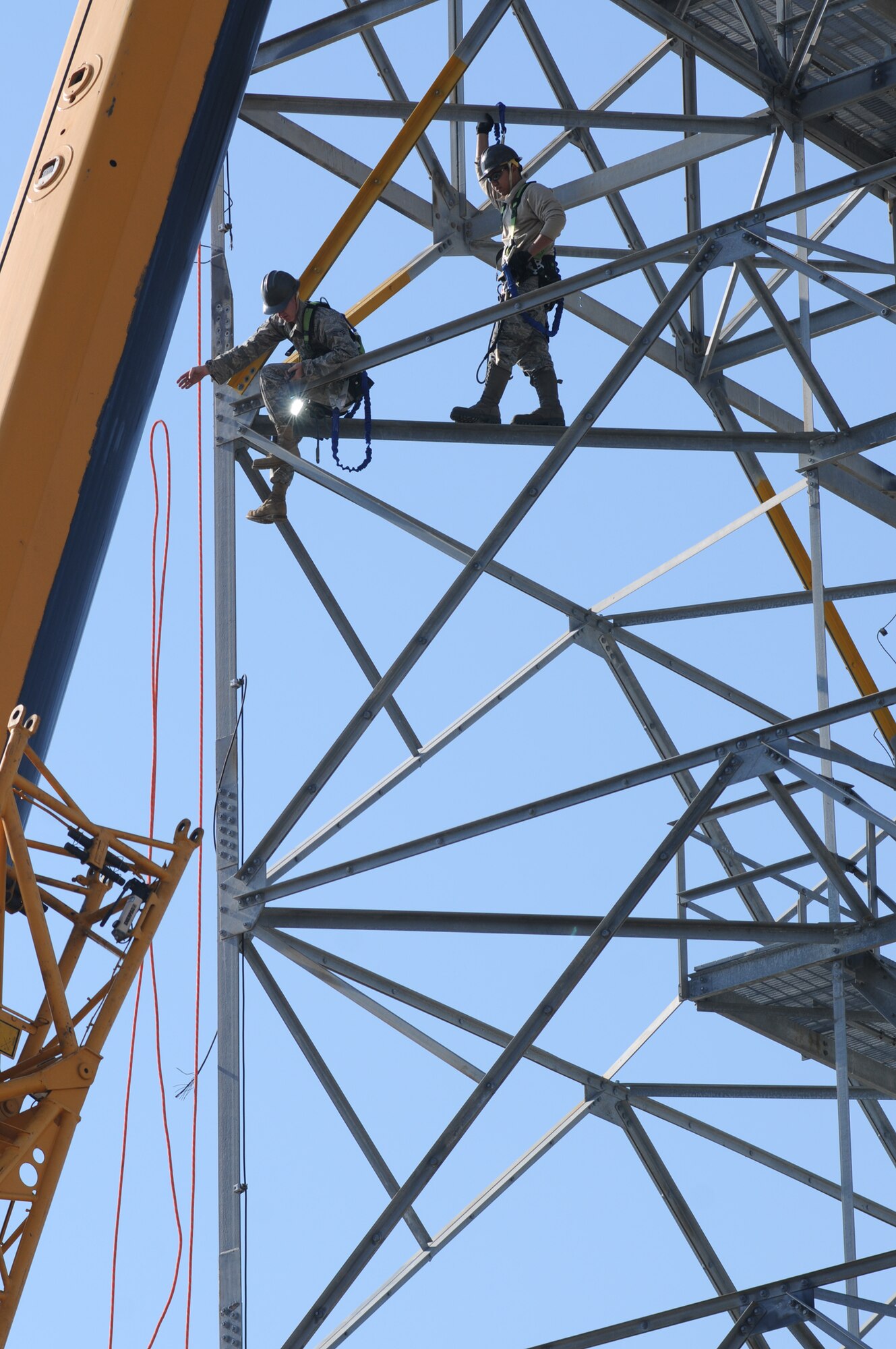 Senior Airman Jeremy Thatcher, left, releases the tag line while Senior Airman Rathanak Ear coordinates with the ground crew as members of the 85th EIS team work on disassembling a GPN-20(V) tower for the 81st Training Group, Feb. 15.  (U.S. Air Force photo by Kemberly Groue)