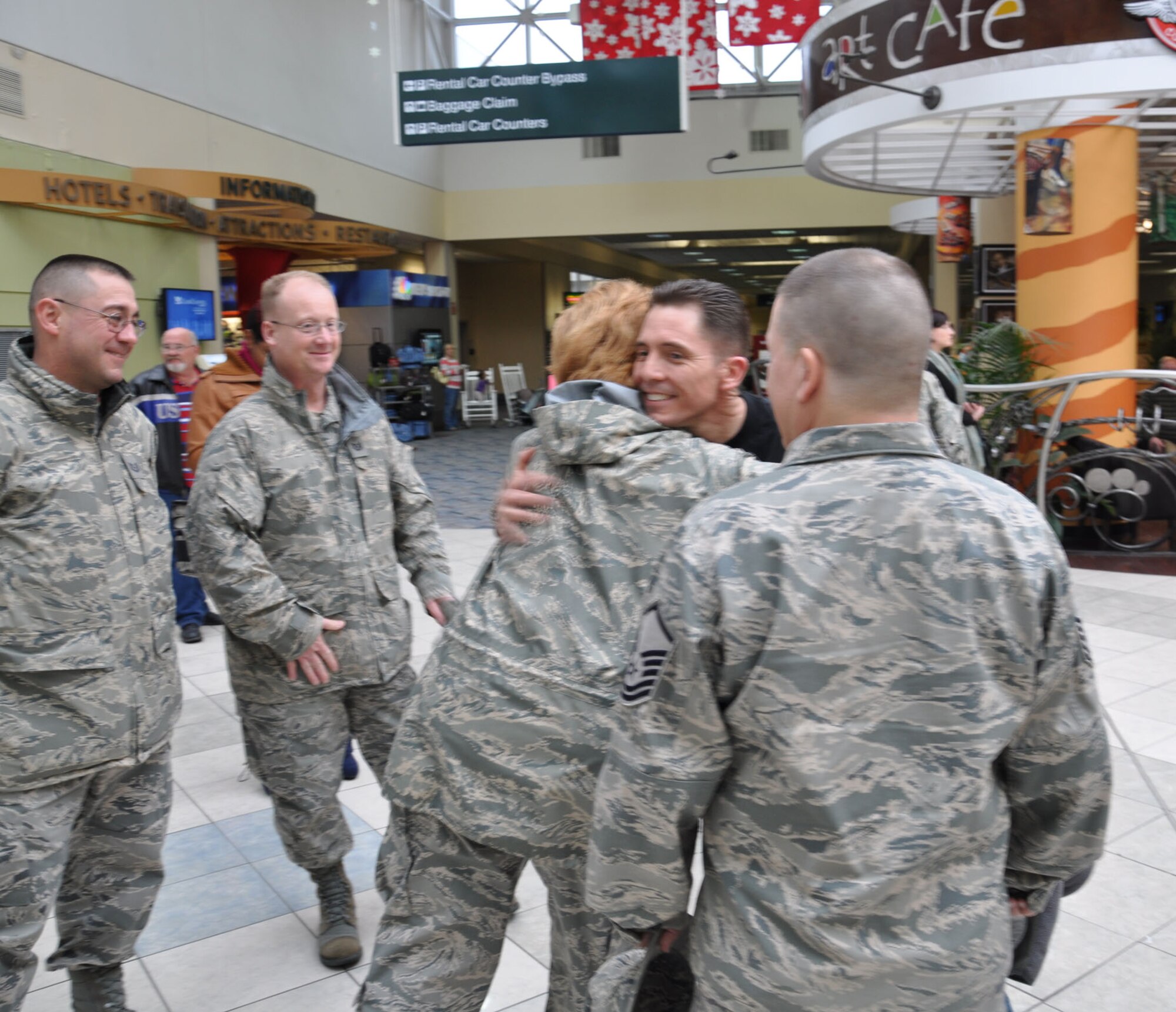 WRIGHT-PATTERSON AIR FORCE BASE, Ohio - Major Jason Ortiz, 87th Aerial Port Squadron, is greeted by his co-workers at the Dayton International Airport March 4 after returning from a six month deployment to Southwest Asia.  During his deployment, Major Ortiz was assigned to the 332nd Expeditionary Logistics Readiness Squadron where he served as the director of operations. (U.S. Air Force photo/ Staff Sgt. Robert Nelson)