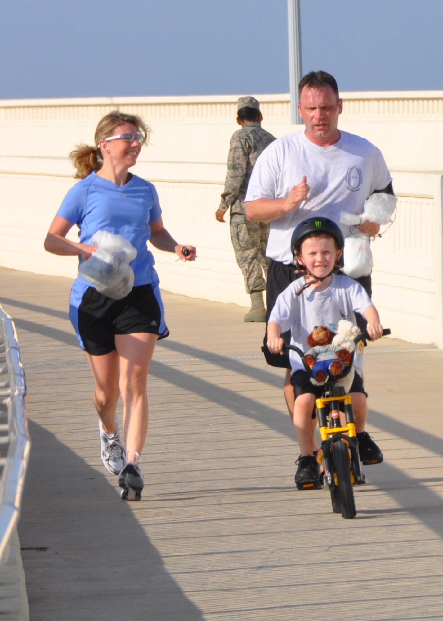 Sergeant Fisher, his wife Holly and their 5-year-old son Tristan head across the Biloxi-Ocean Springs Bridge with teddy bears during Saturday’s run.  (U.S. Air Force photo by Steve Pivnick)