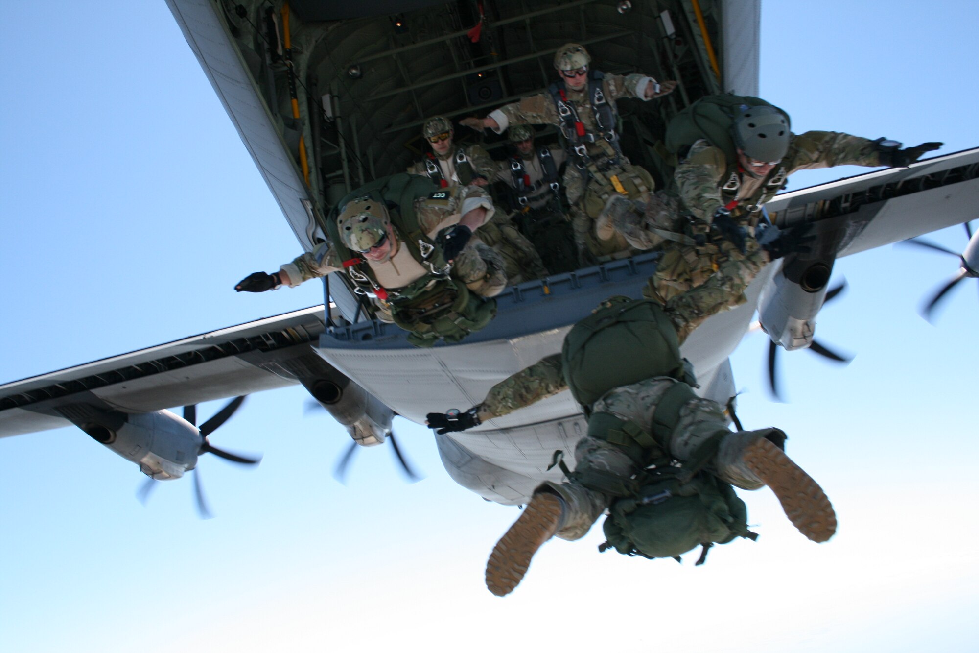 Master Sgt. Jake Chandler, back to camera; Staff Sgts. Matthew Pich and
Christopher Vroman, front row from left; and Tech. Sgt. Robert Parra, Staff Sgt.
Michael McCormick and Tech. Sgt. Daniel Nestor, back row from left, perform
a military free fall from a 403rd Wing C-130J Hercules March 18 in preparation
for Keesler’s Angels Over the Bay Air Show and Open House March 19-
20. Sergeant Chandler is a combat control instructor supervisor and Sergeants
Pich, Vroman and McCormick are combat control instructors in the 334th
Training Squadron. Sergeant Parra is a combat control instructor and Sergeant
Nestor is a tactical control party instructor with the 342nd TRS, Lackland Air
Force Base, Texas. A military free fall is a precision airborne insertion technique
used by special operations teams. Forces can be accurately inserted miles from
the intended landing area while carrying more than 100 pounds of equipment.
Sergeant Chandler said the group was able to conduct nine training jumps, up
to a combat equipment jump with 50-pound ruck sacks attached to their parachutes
before leaving the plane at 10,000 feet. The instructors make quarterly
jumps to remain proficient in their skills.  (U.S. Air Force photo by Tech. Sgt. Wesley Bonin)